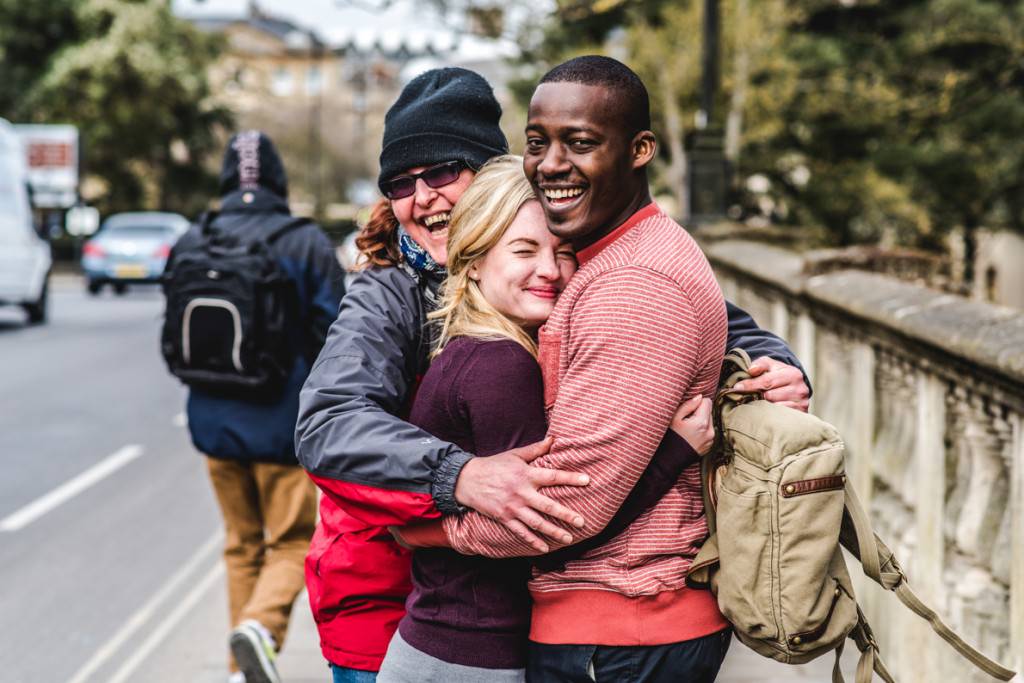 An engaged couple being hugged