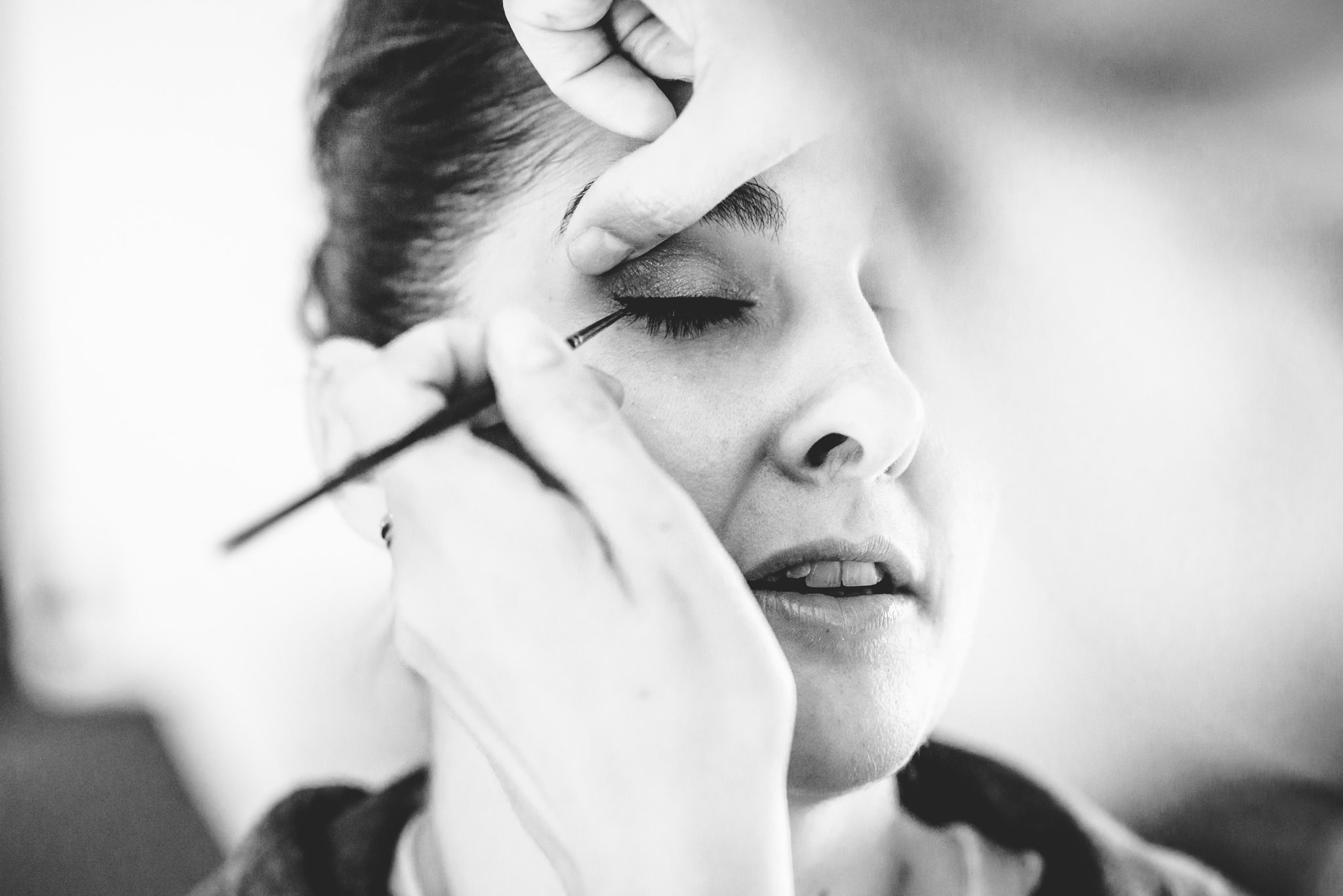 A close up of a bride having make-up applied