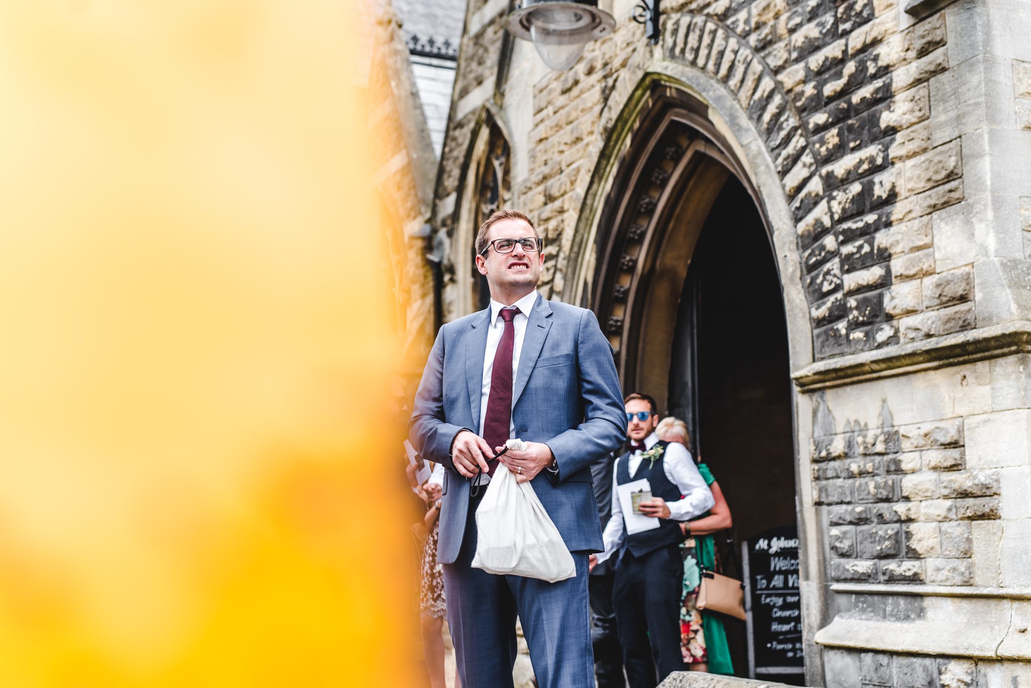 man holding a bag outside a wedding ceremony