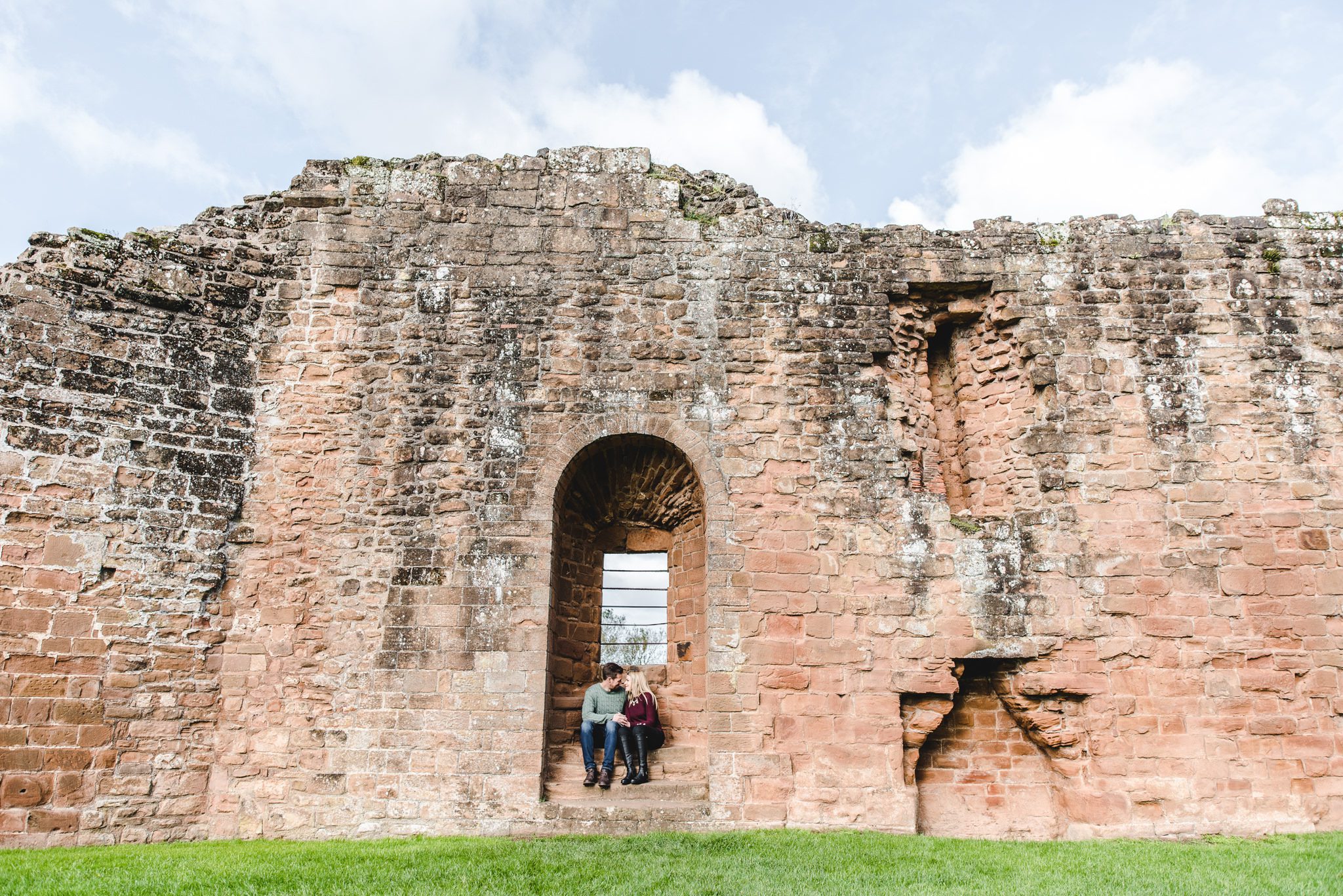 A wide view of a couple sat in an alcove at Kenilworth Castle