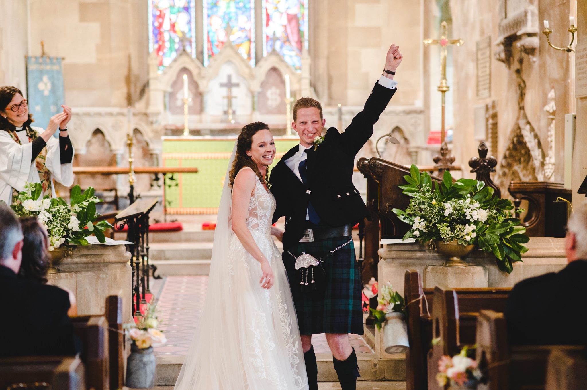 Bride and groom with arms in the air in tetbury after being announced as man and wife