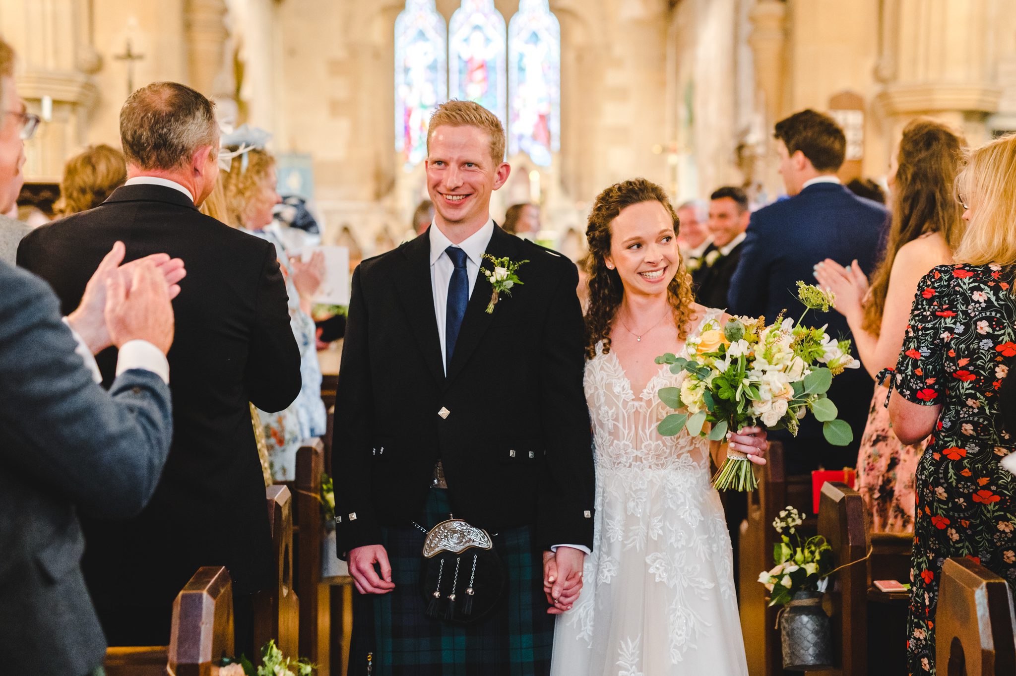 Couple walking back down the aisle in tetbury