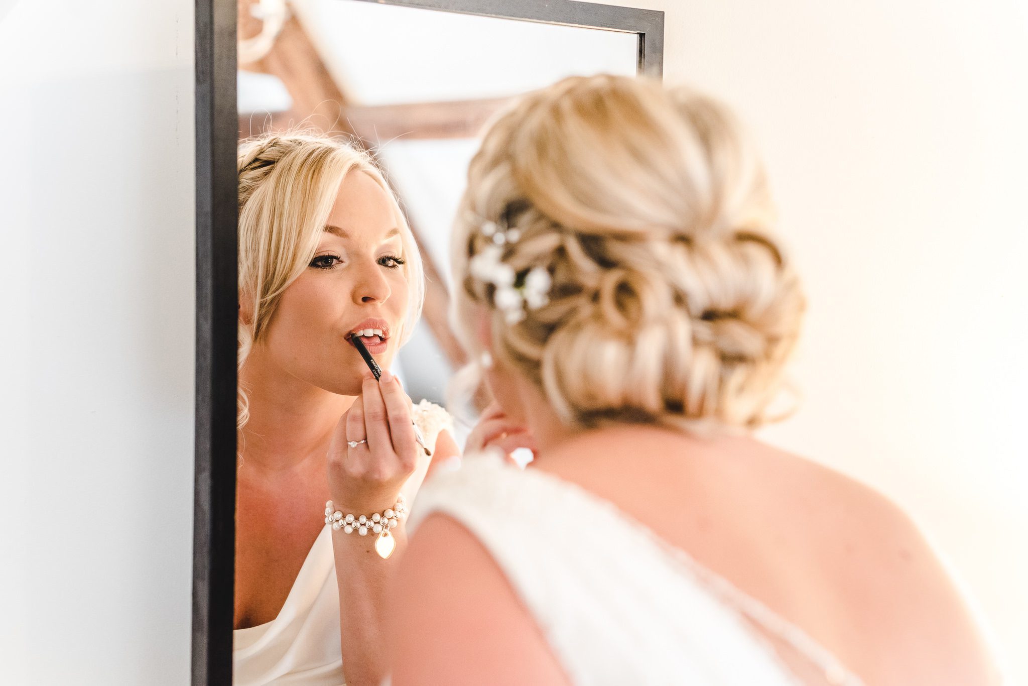A bride applying lipstick