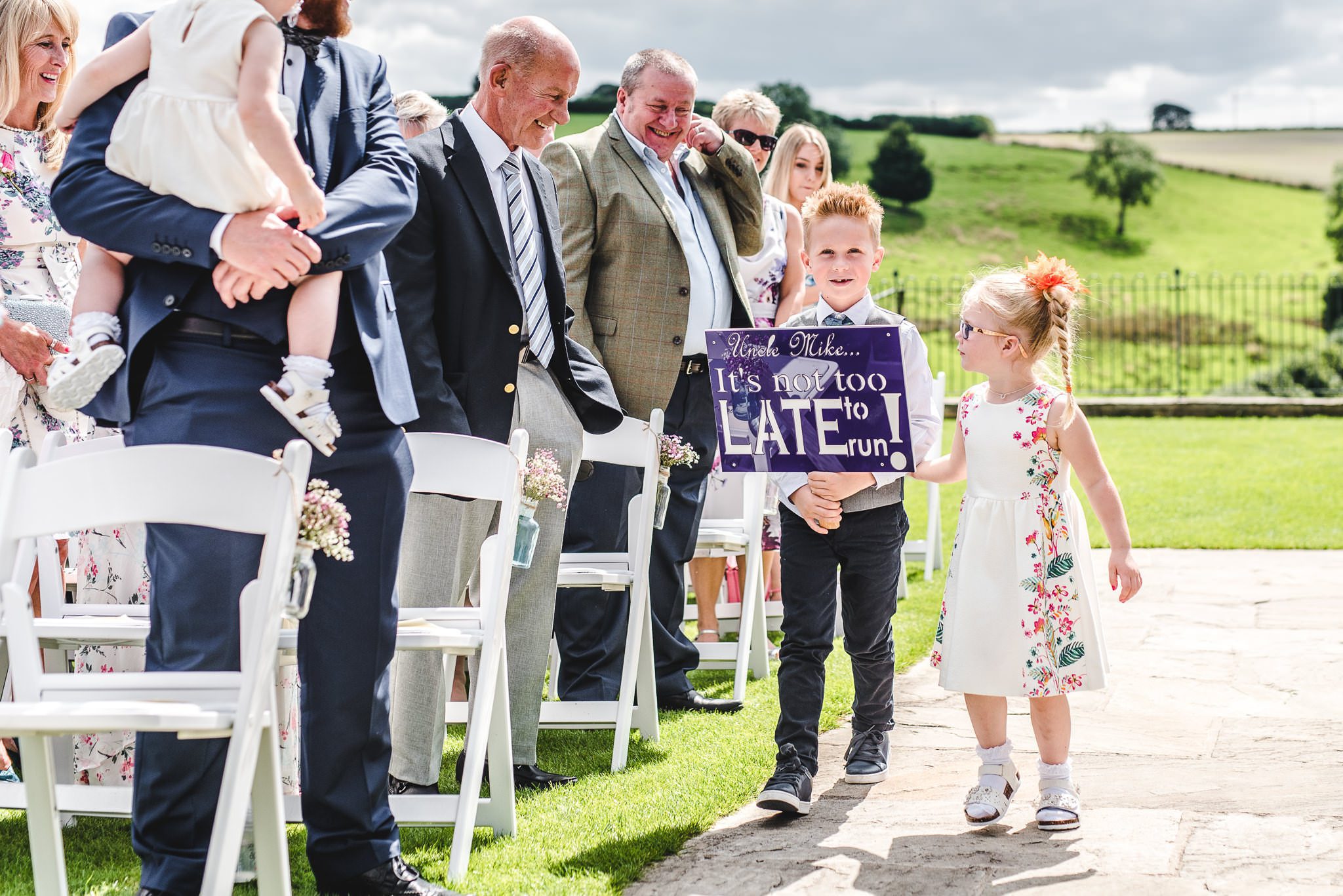 A page boy carrying a sign at a wedding