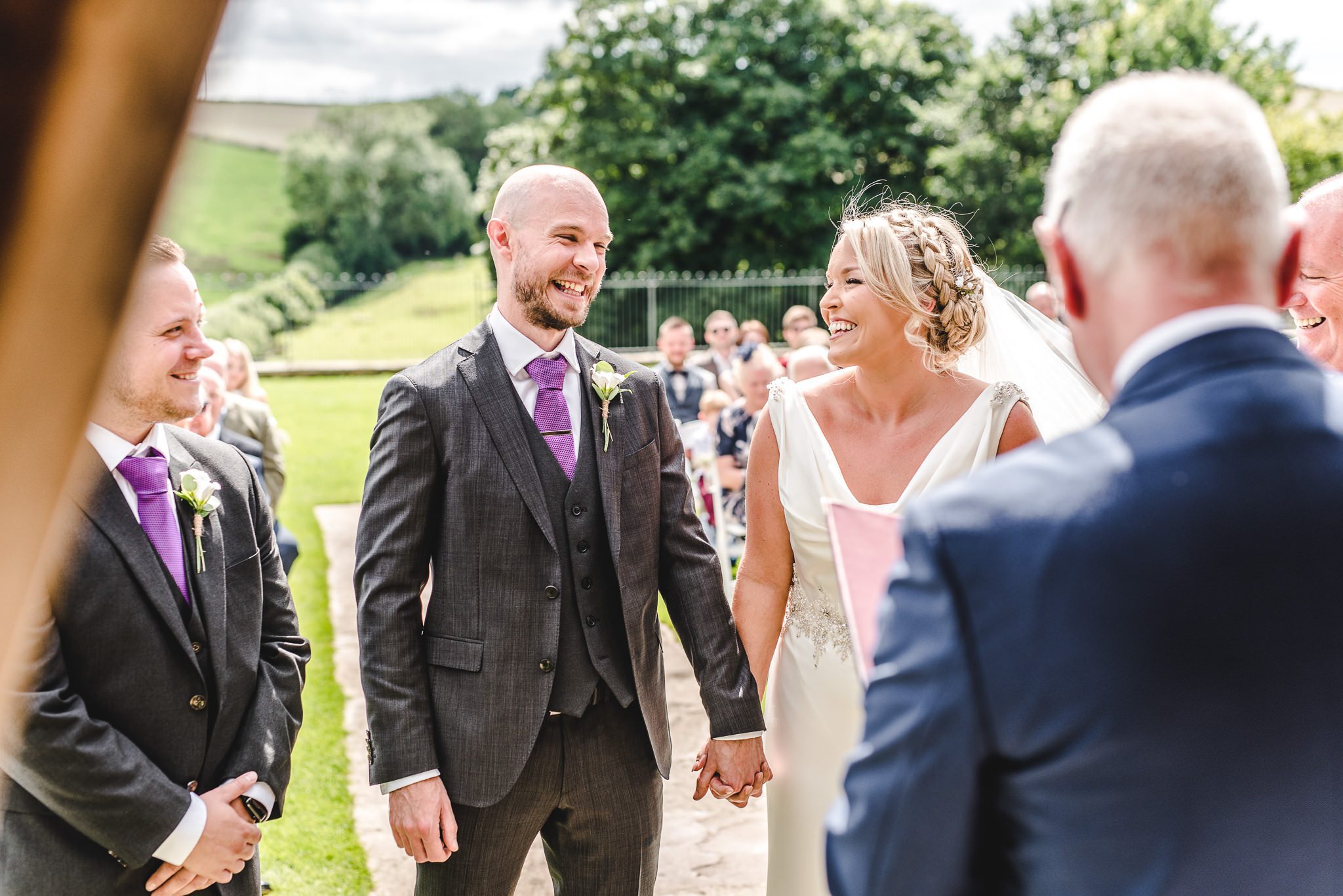 A groom and a bride getting married at Kingscote Barn