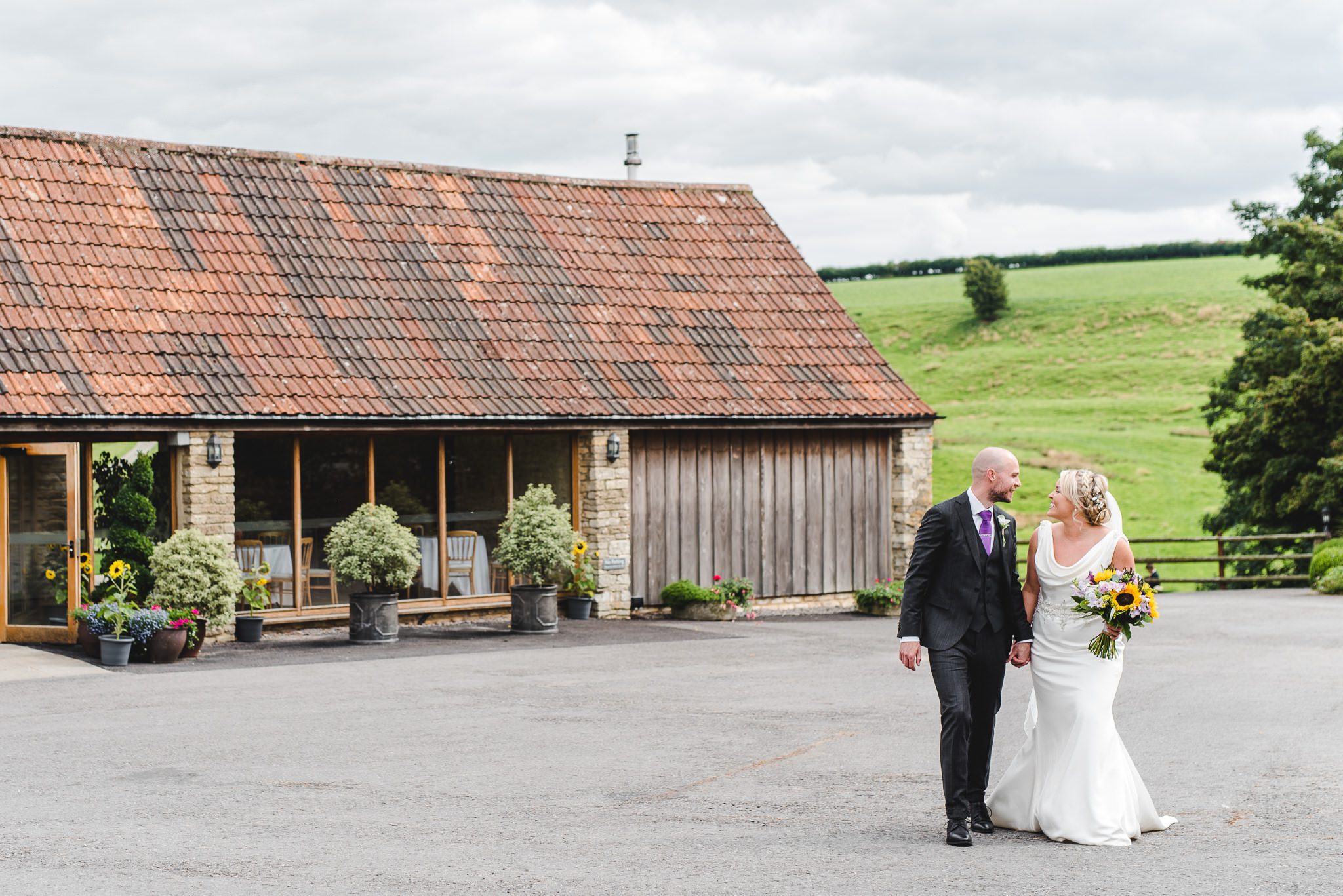 A bride and groom outside Kingscote Barn