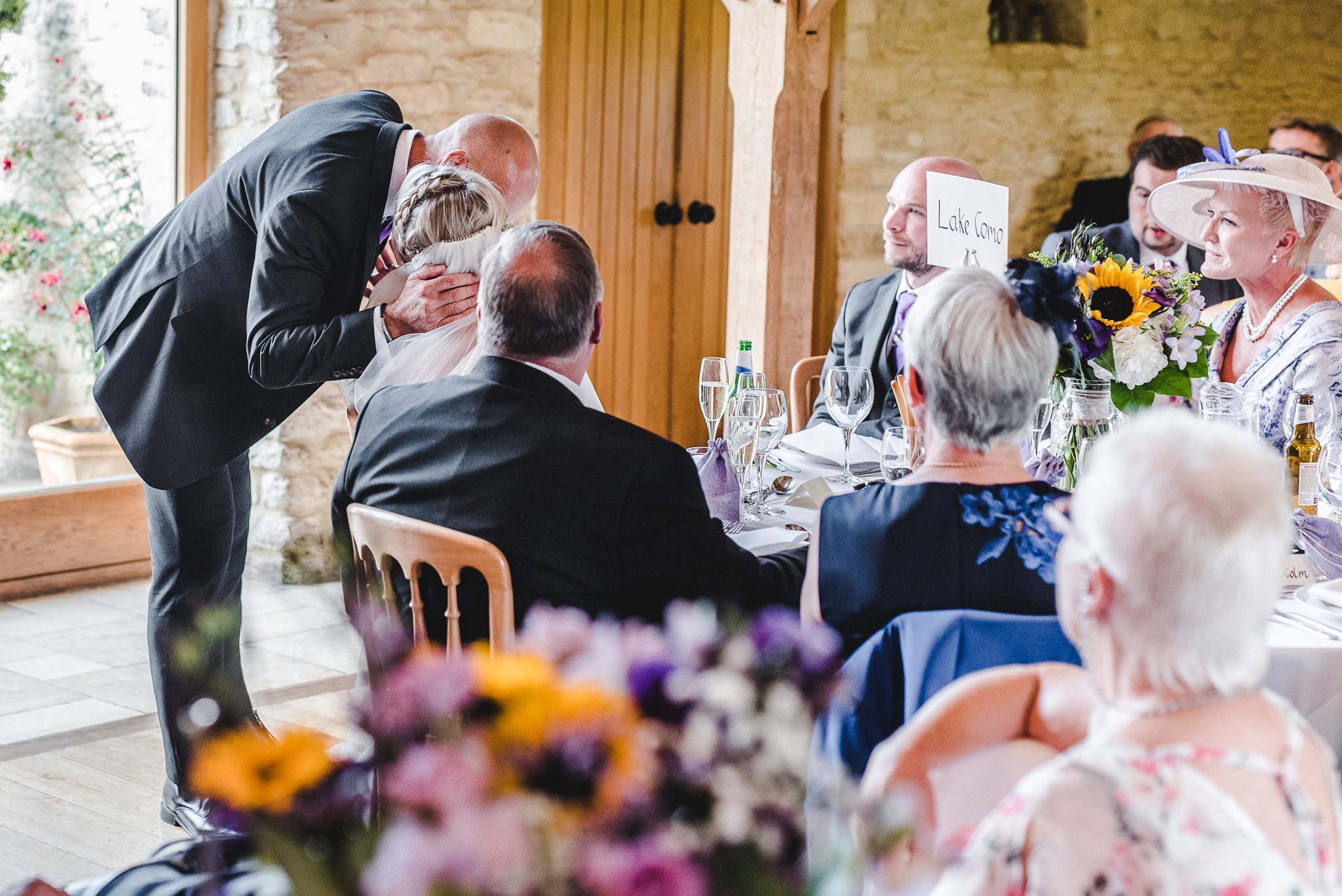 A bride being kissed by her father during his wedding speech