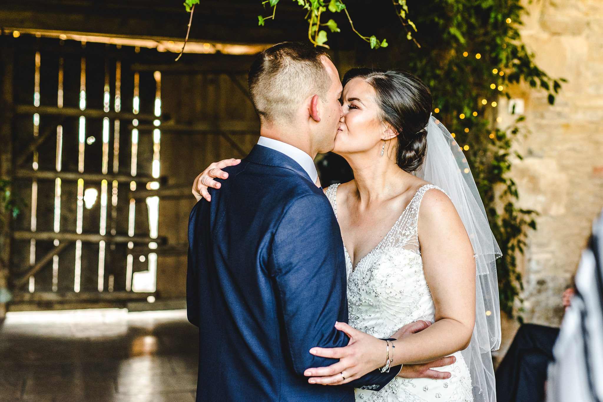 Bride and Grooms first kiss at stone barn wedding ceremony