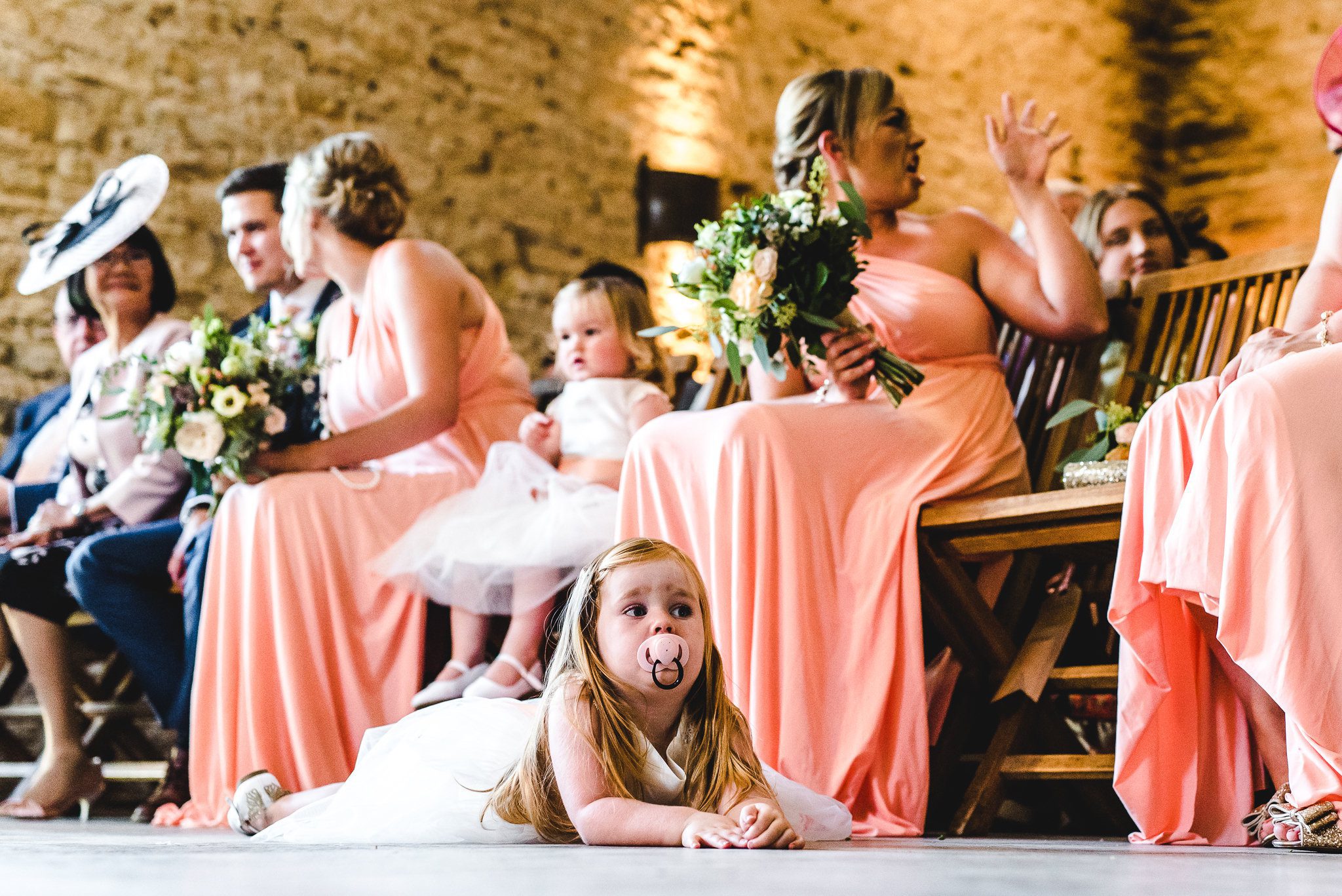 A flower girl laying on the floor at stone barn