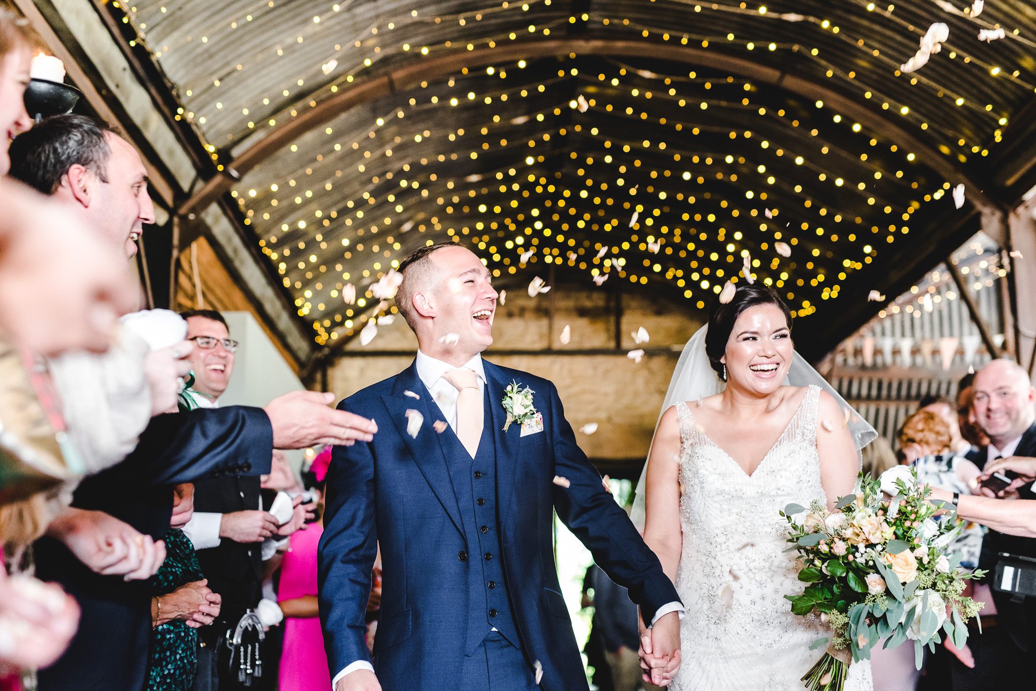 Confetti amongst the fairy lights at Stone Barn in Gloucestershire