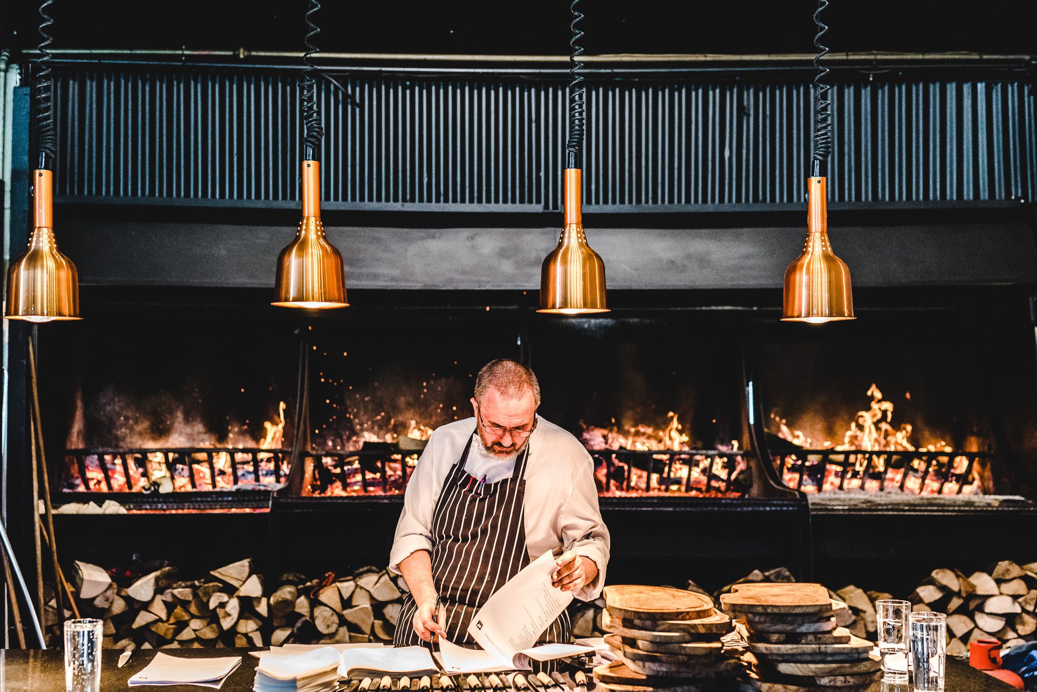 Chef in the kitchen looking through notes at stone barn