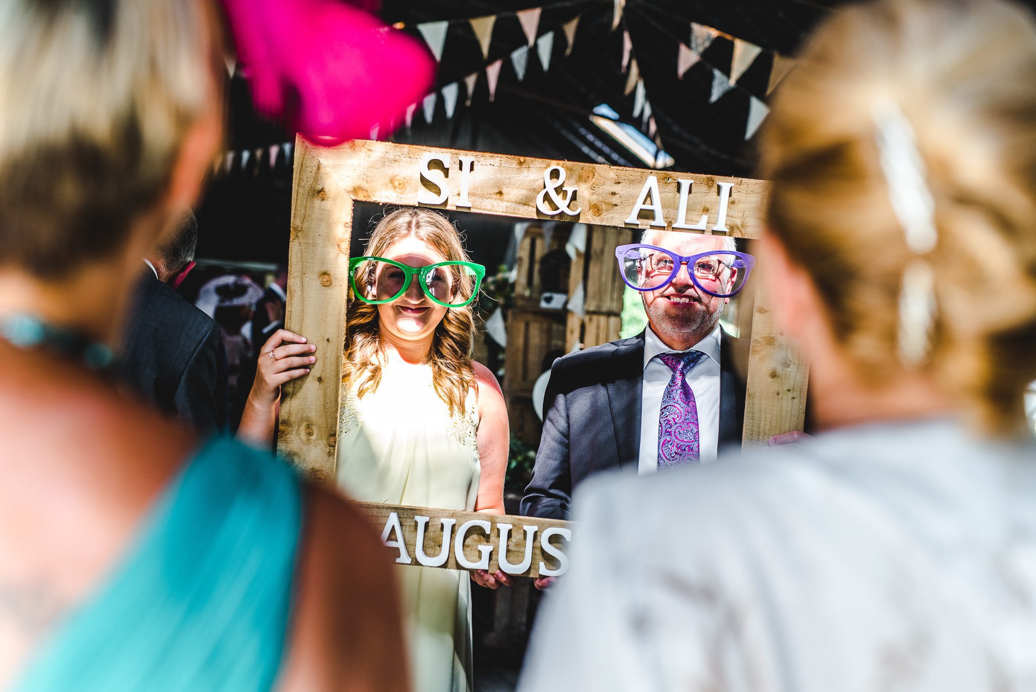 Wedding guests behing picture frame at stone barn