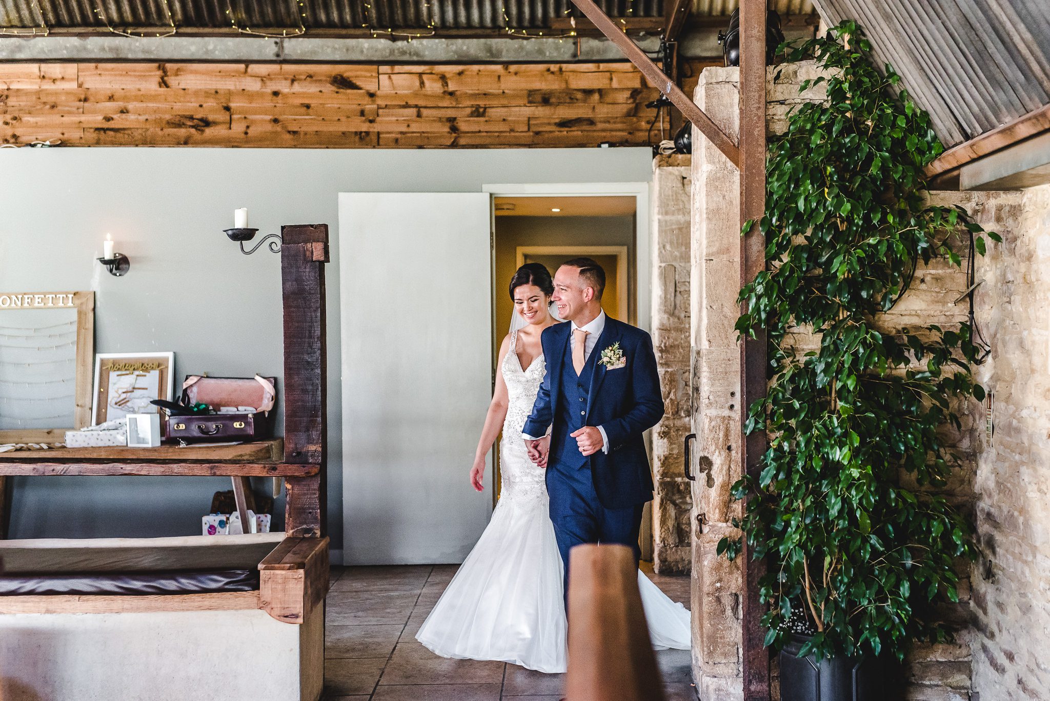 Bride and Groom entering their wedding reception at stone barn