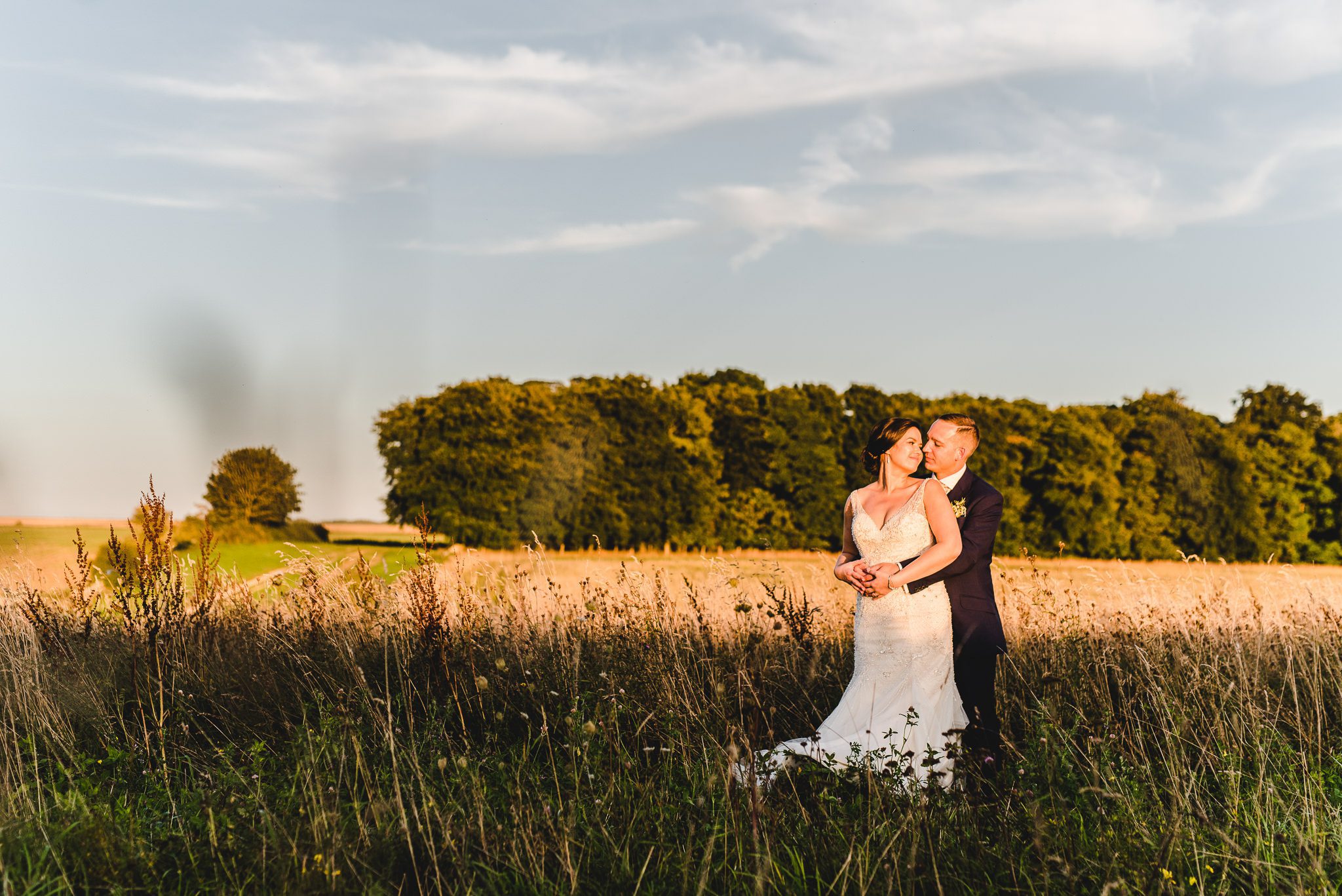 Bride and groom portraits in a field at stone barn