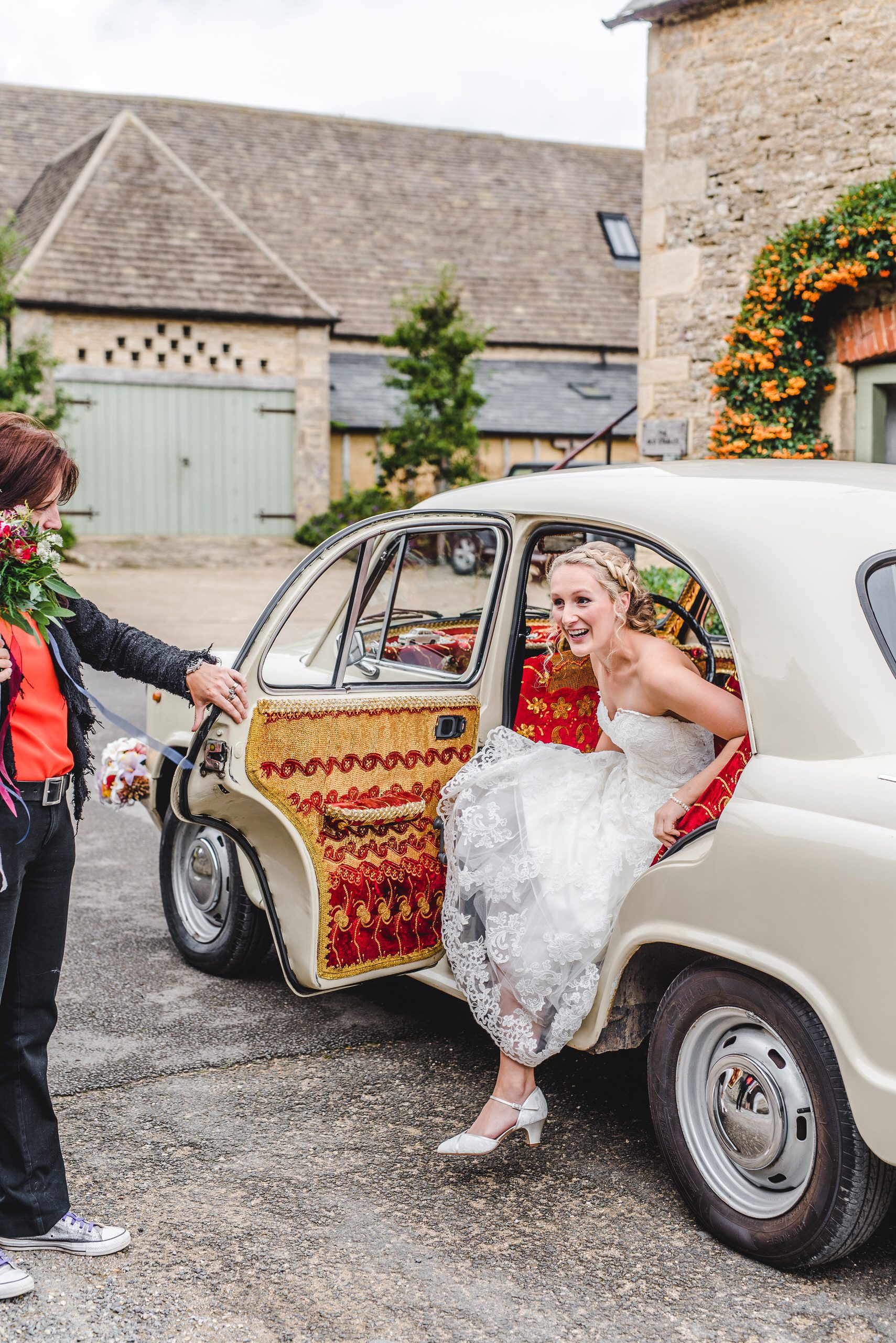 Bride getting out of her car at Oxleaze Barn