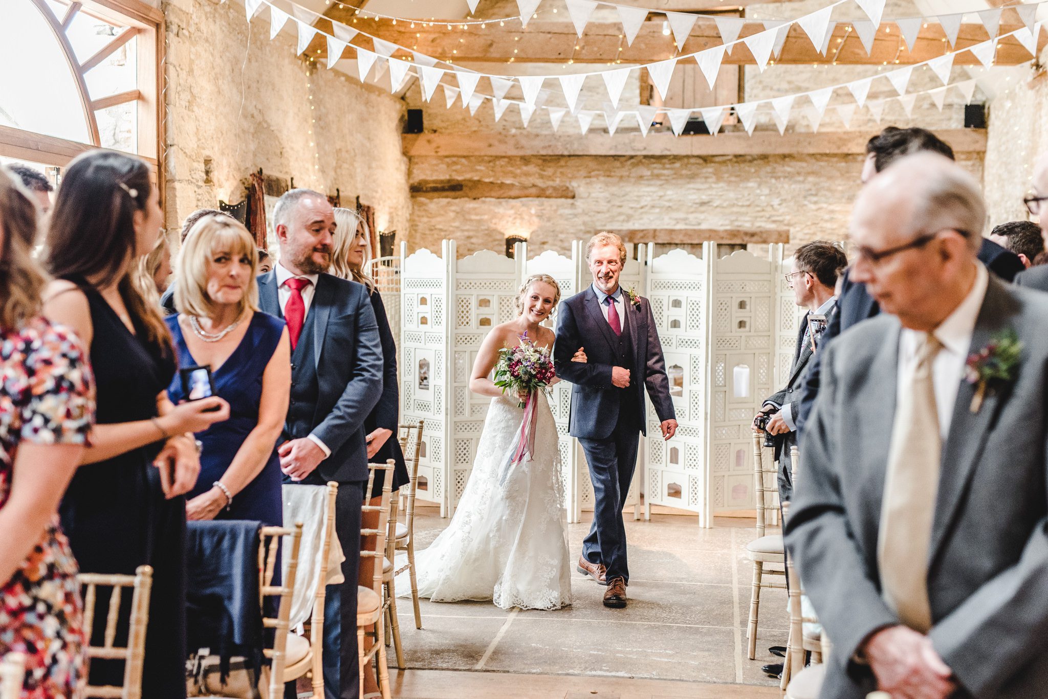 Bride and her father walking down the aisle at Oxleaze Barn