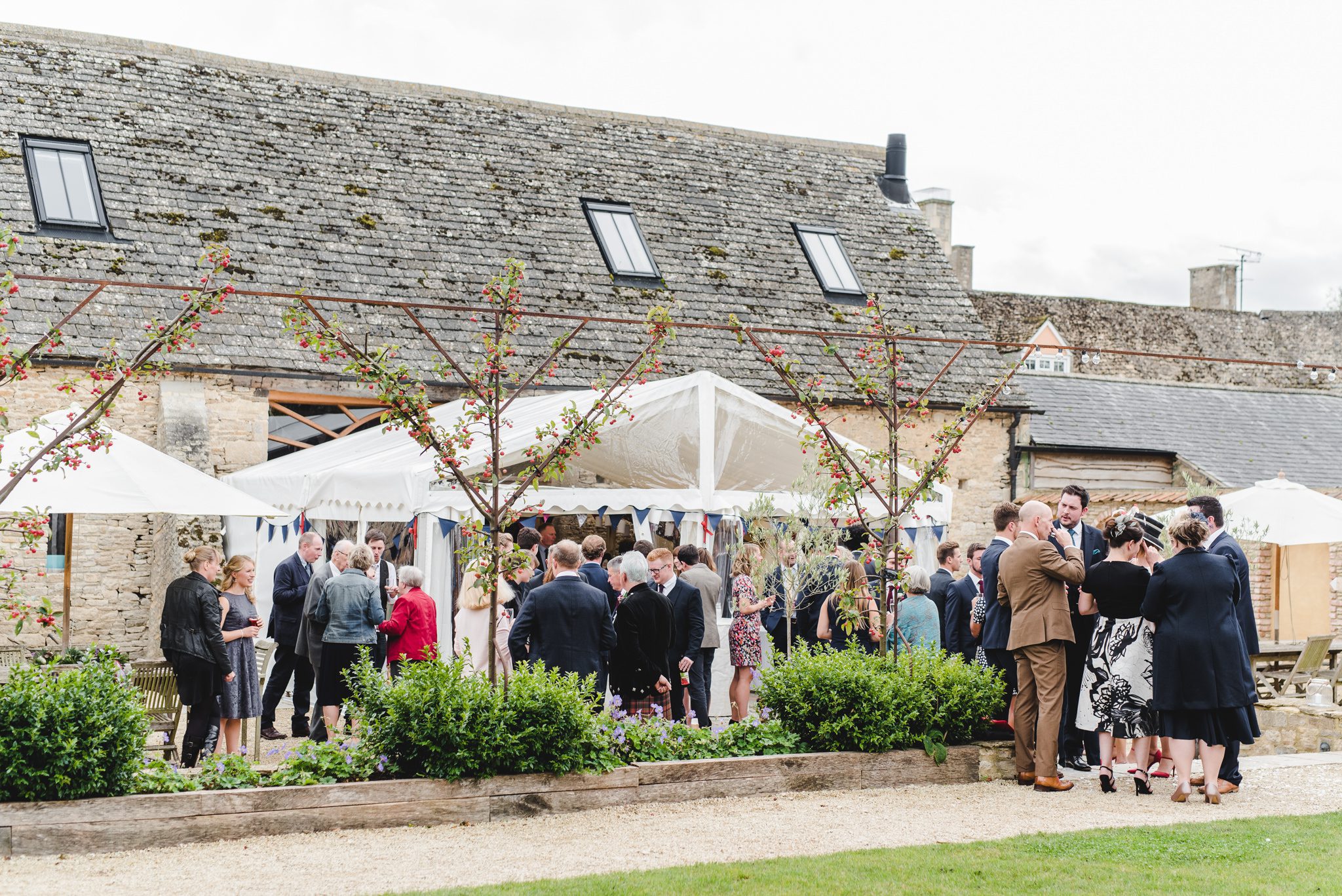 Wedding guests enjoying drinks and canapes at Oxleaze Barn wedding venue