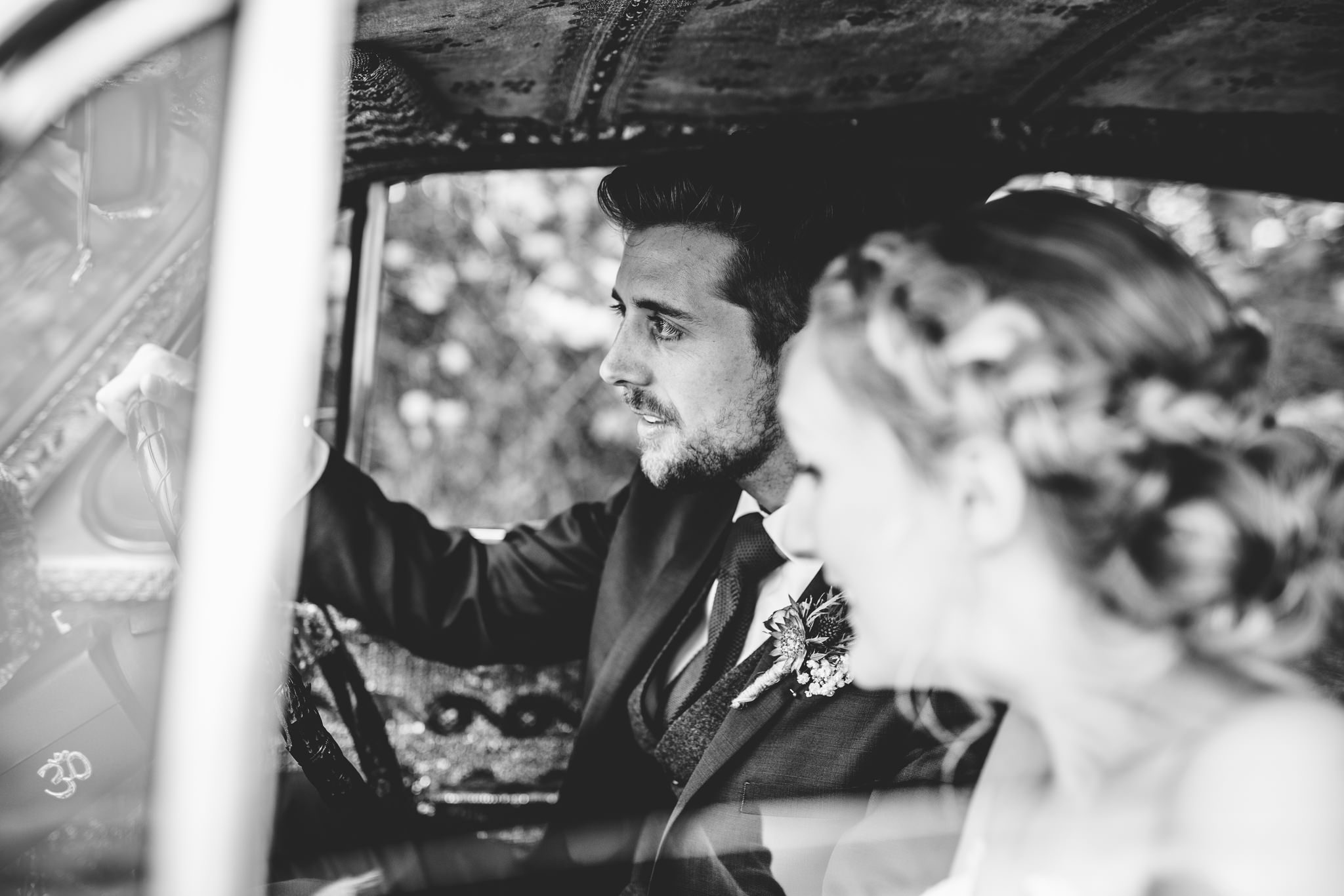 Groom driving a car down the drive at Oxleaze Barn