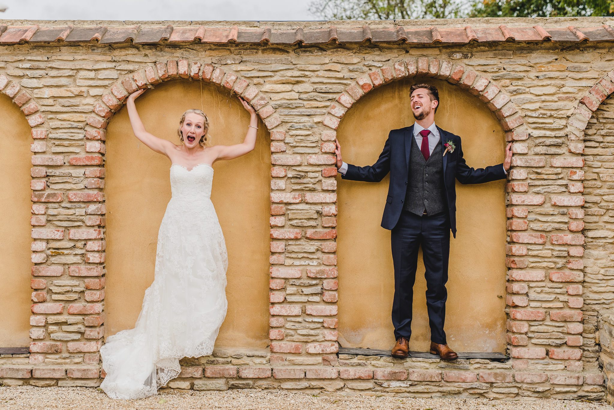 Fun wedding photo of a bride and groom standing in an alcove