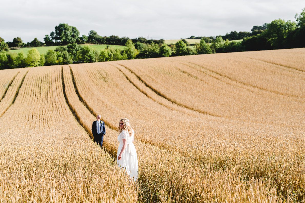 Upcote Barn wedding couple posing in a field for photographs