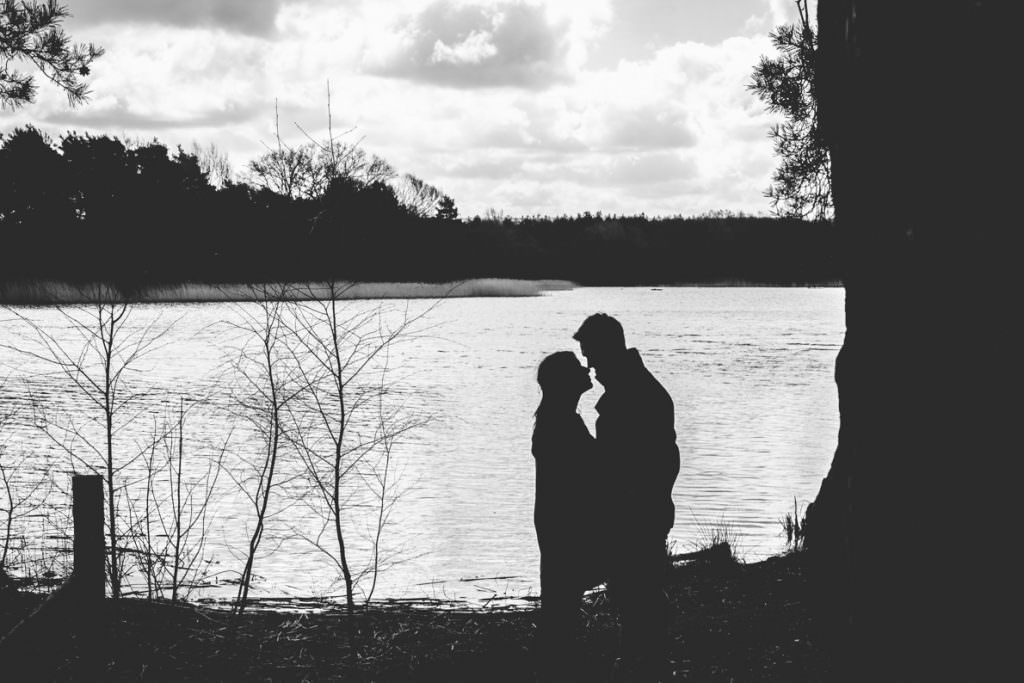 A couple silhouetted against a lake