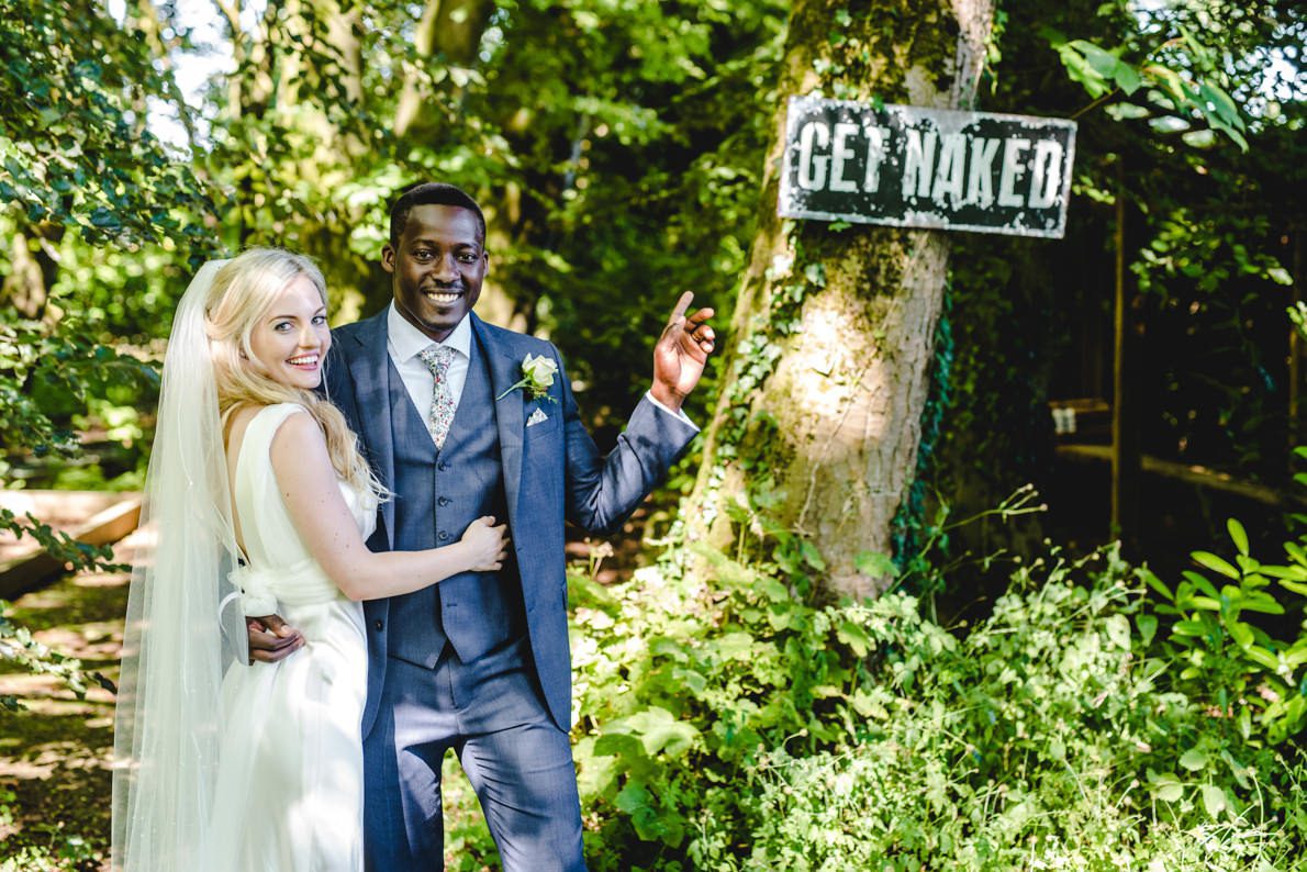 A couple at their Matara Wedding standing in front of a GET NAKED sign