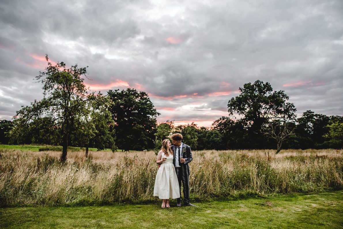 A couple at an Elmore Court Wedding with a beautiful sunset behind