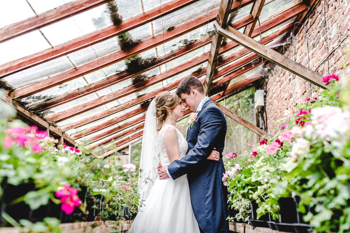 A Birtsmorton Court Photography couple stood in a greenhouse