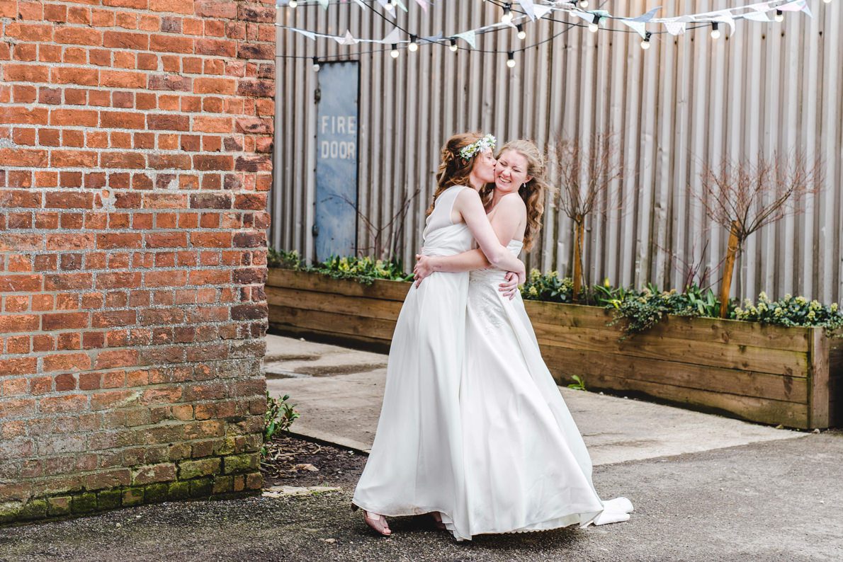 Two brides hugging at their Gloucestershire Brewery Wedding