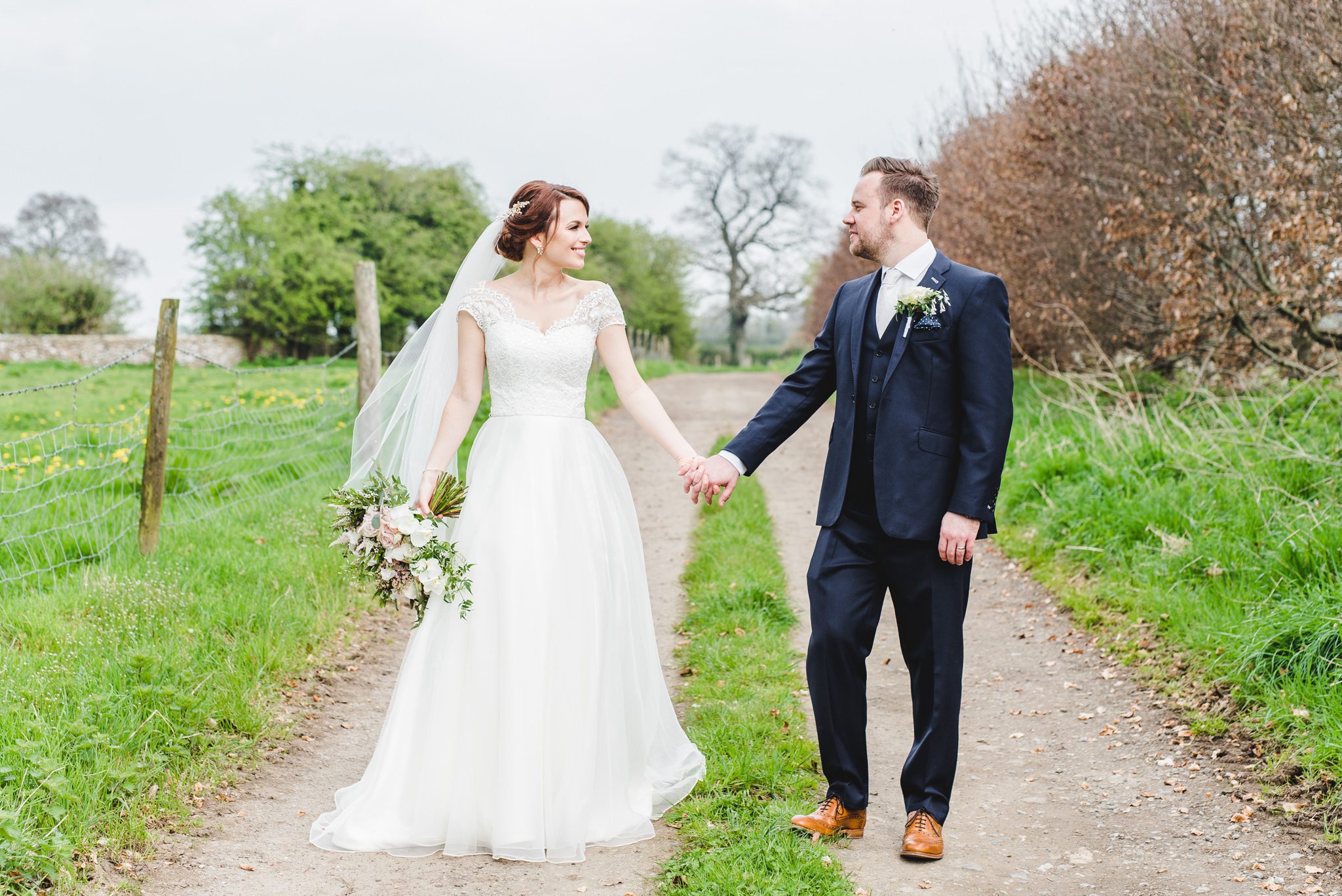 Bride and Groom holding hands on a beautiful pathway