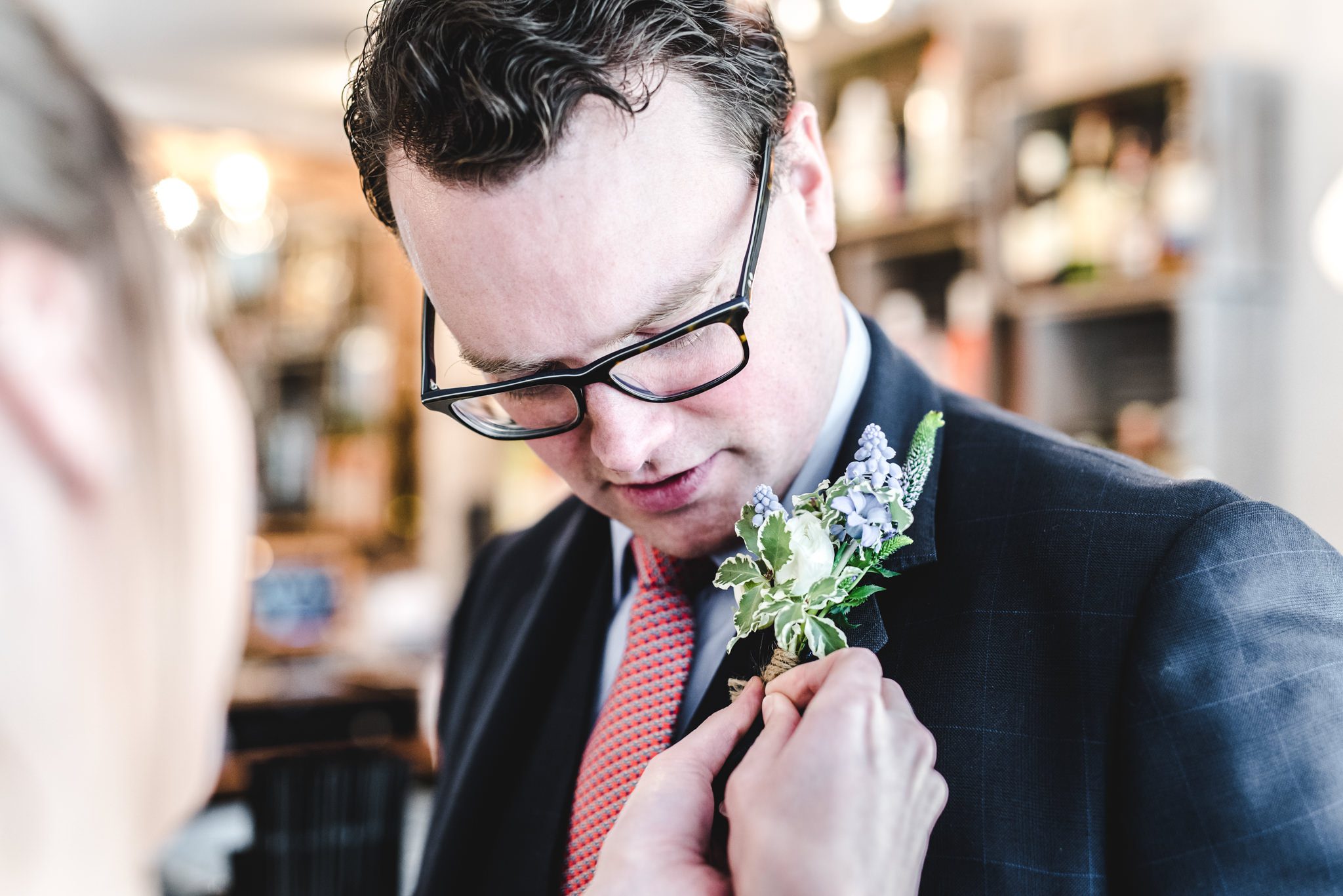 Groom having buttonhole attached