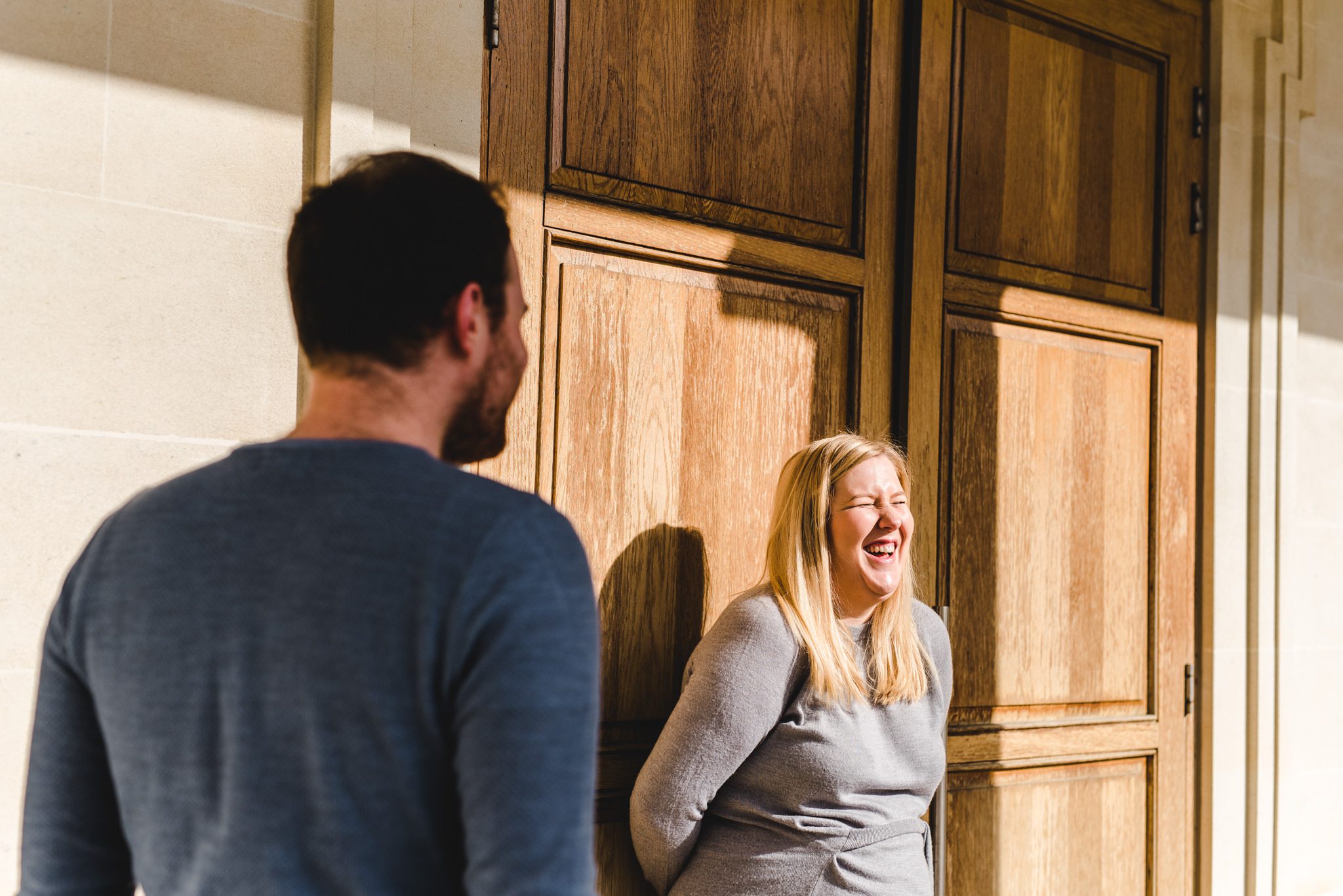 A pregnant bride laughing in the sunlight