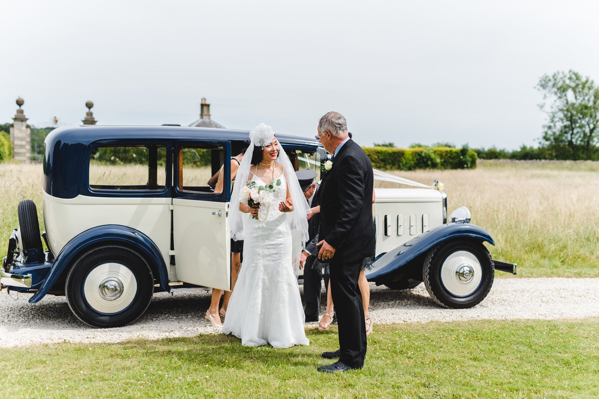 Chinese bride getting out of her car at a lodge park wedding