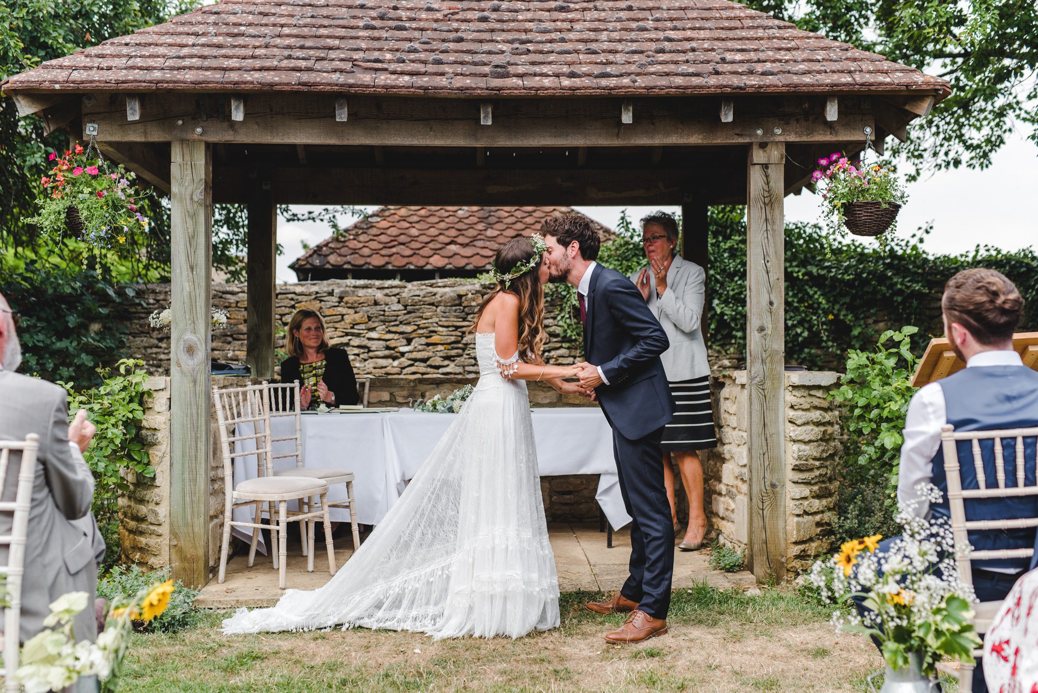 First kiss outdoors in front of the ceremony arch