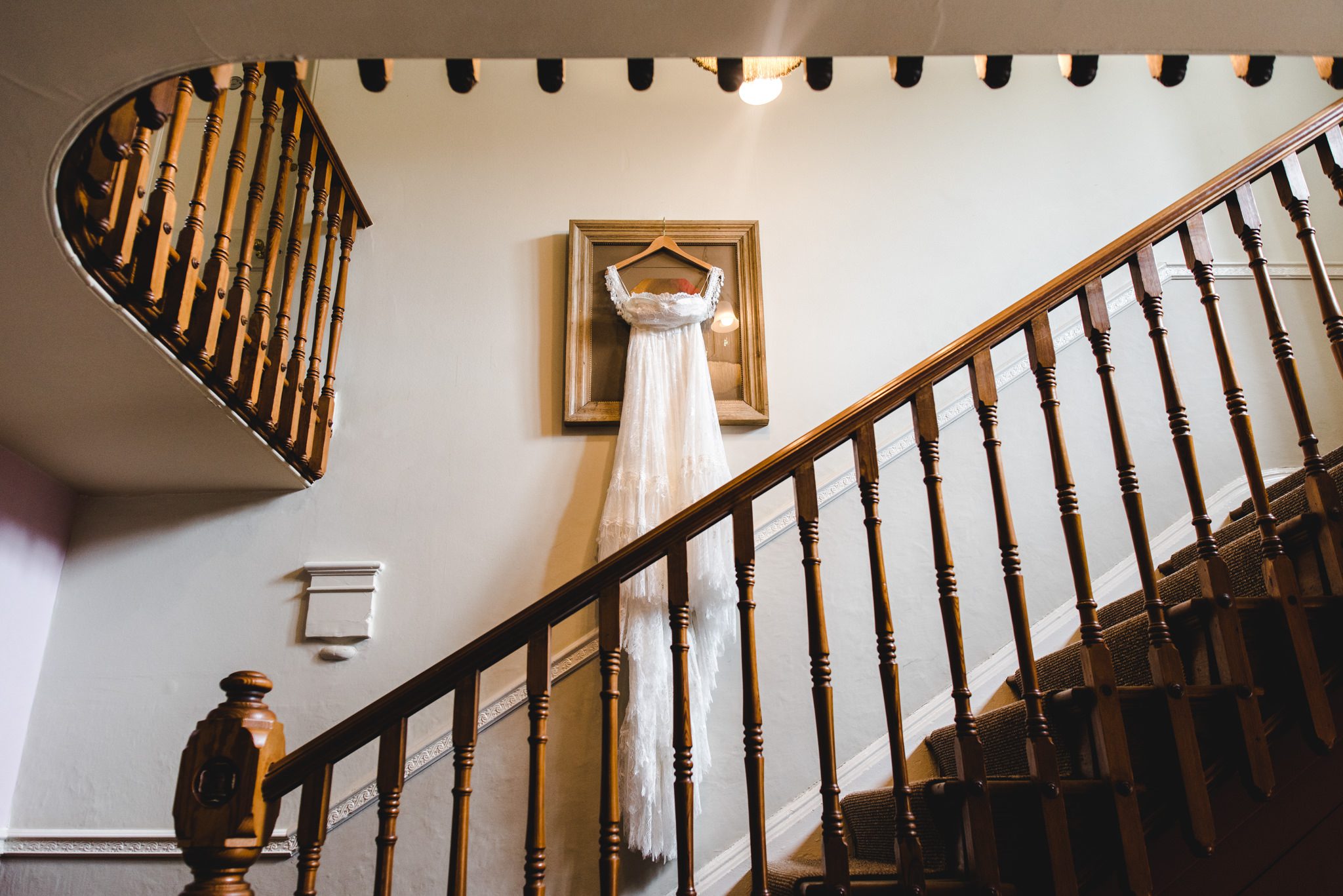 brides dress hanging from a picture frame