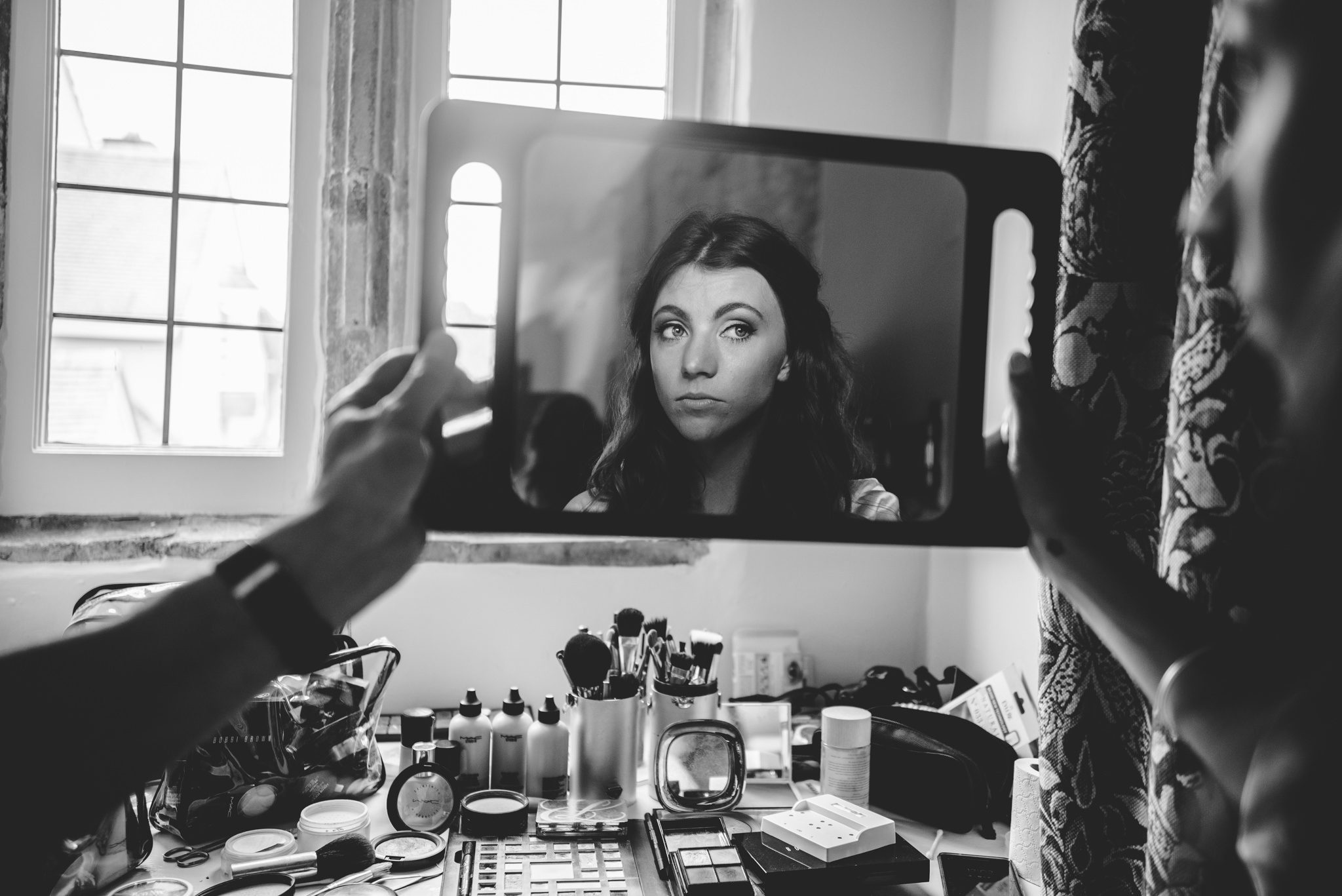 bride looking in the mirror at a wedding getting ready