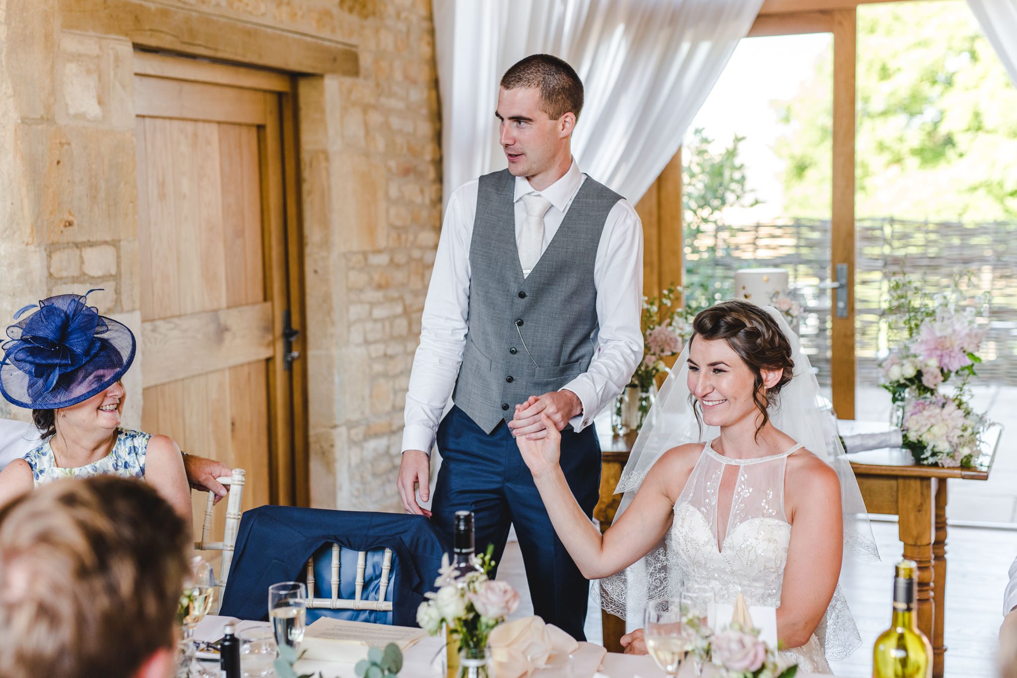 Groom holding wife's hand during speech