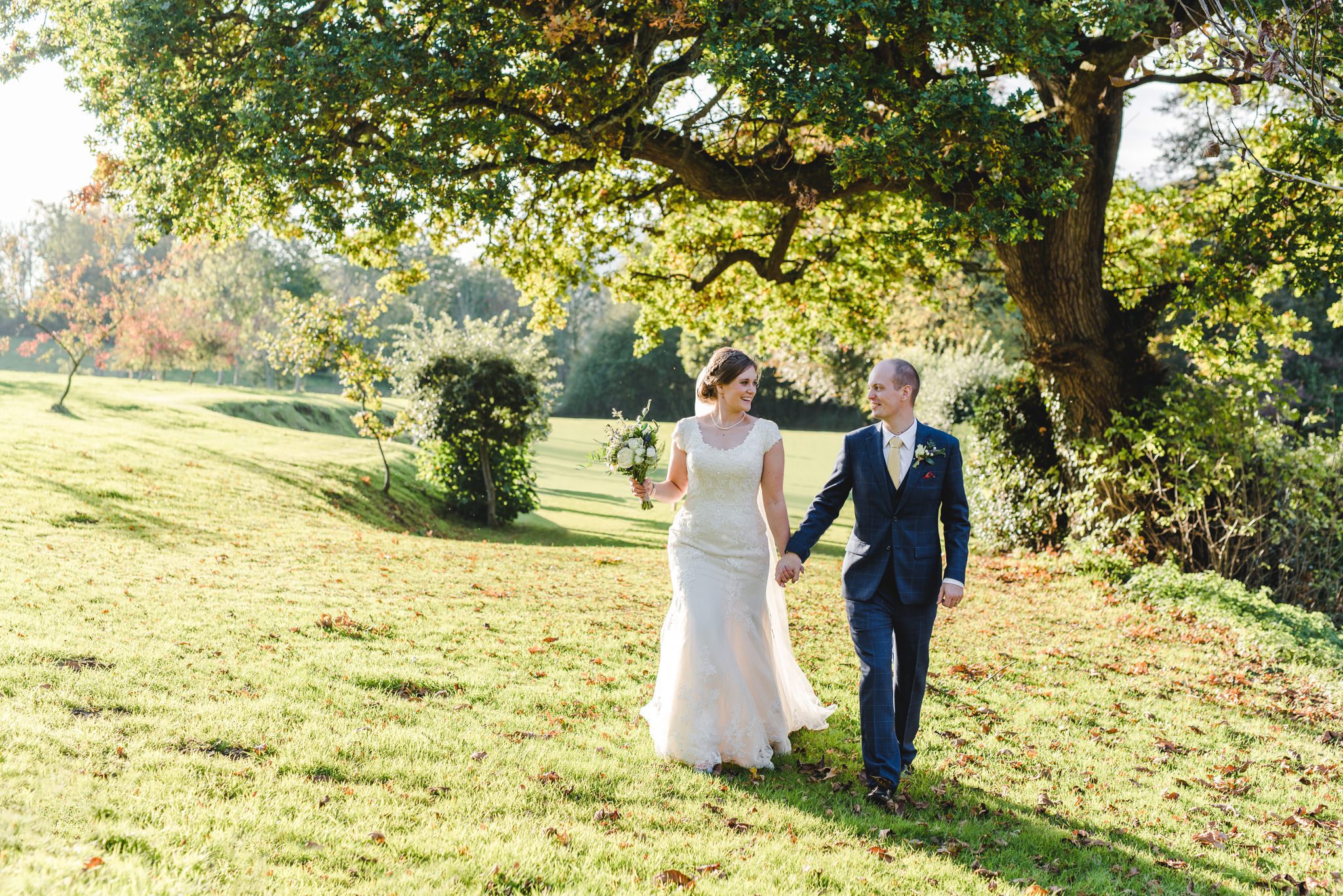 A bride and groom walking in the grounds at Owlpen Manor