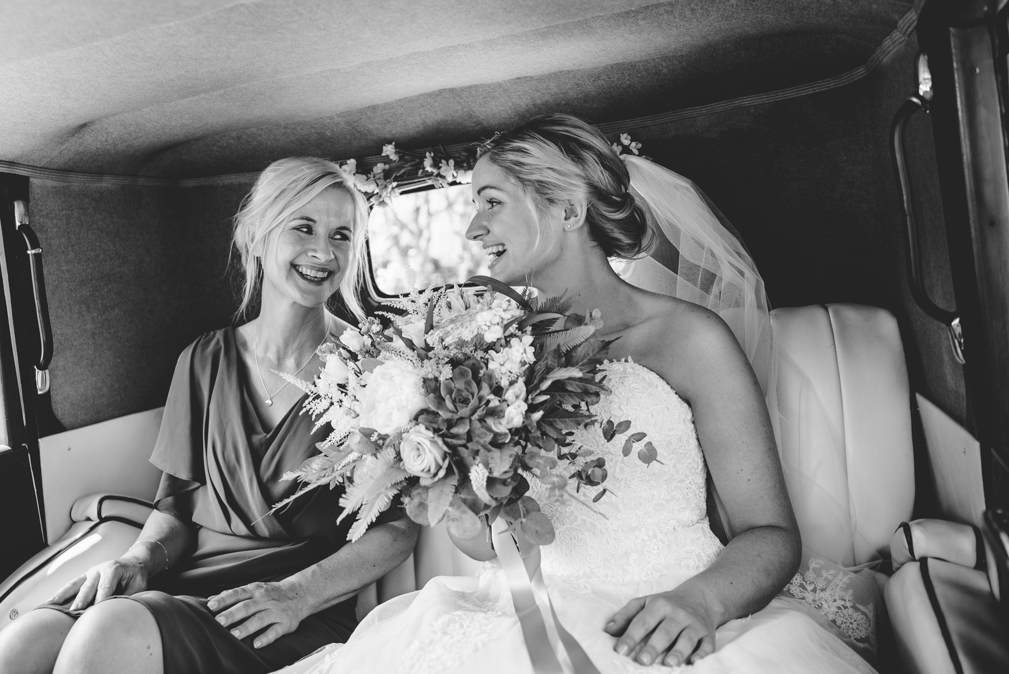 A bride and her mum in their wedding car