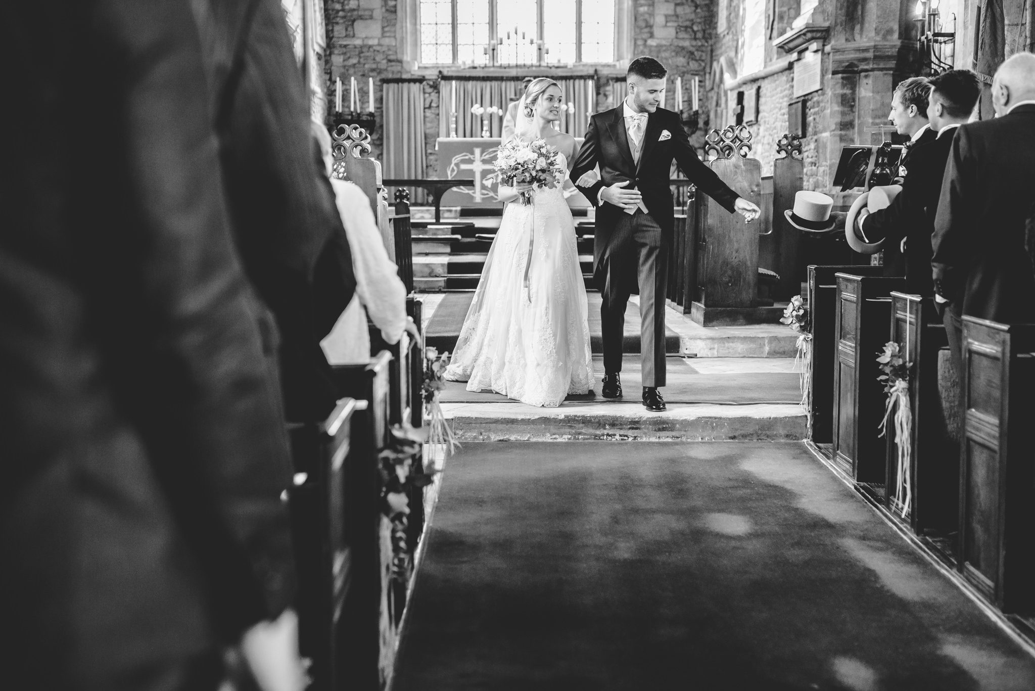 A groom grabbing his hat before his walk back down the aisle at hawkesbury church