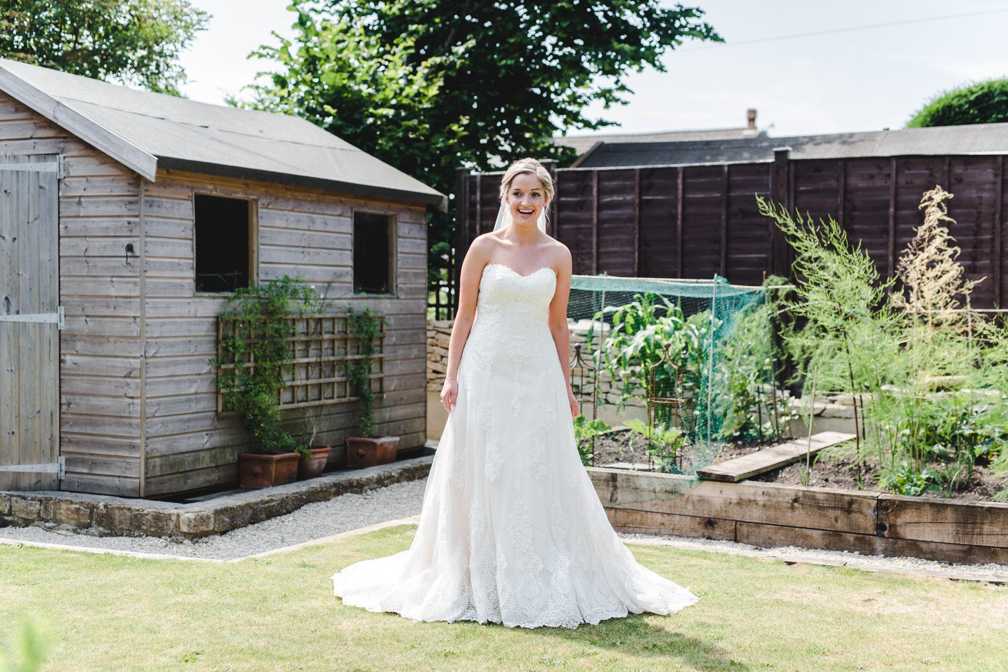 A bride in her wedding dress standing in her garden