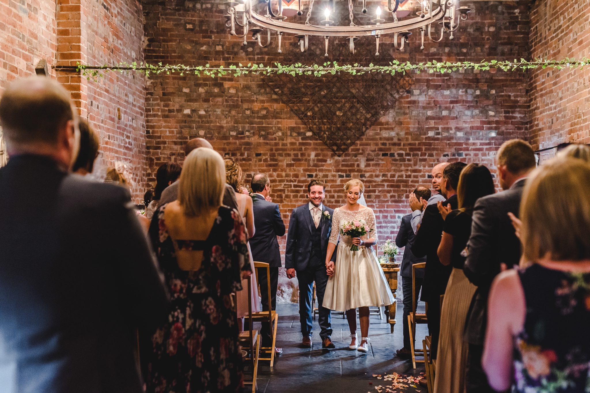 Bride and groom walking back down the aisle smiling