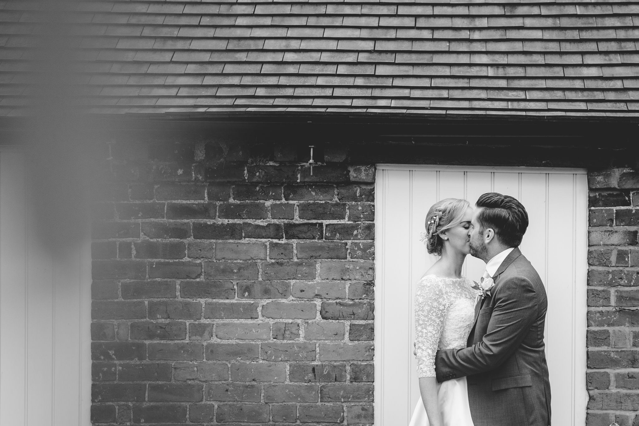 Black and whote picture of a couple kissing at a curradine barns wedding
