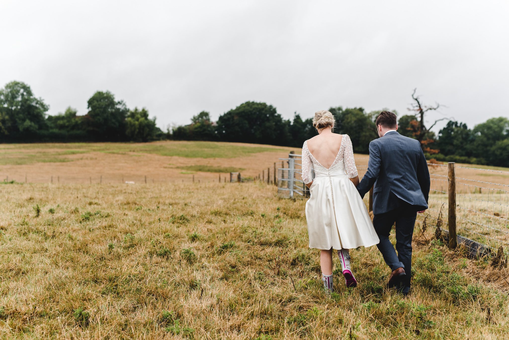 A coule walking away from the camera with their wellies on at Curradine Barns