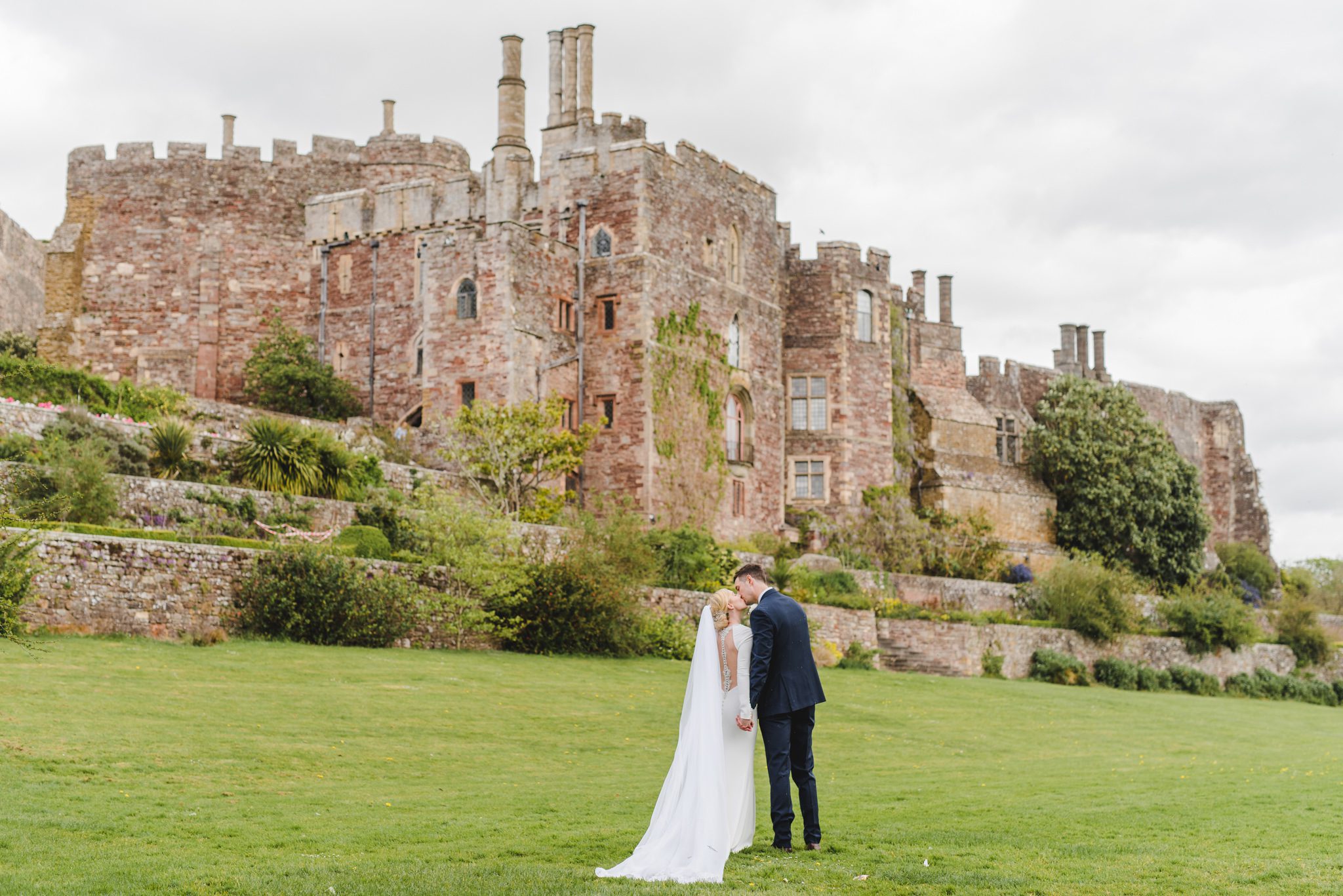 A couple kissing with Berkeley Castle in the background