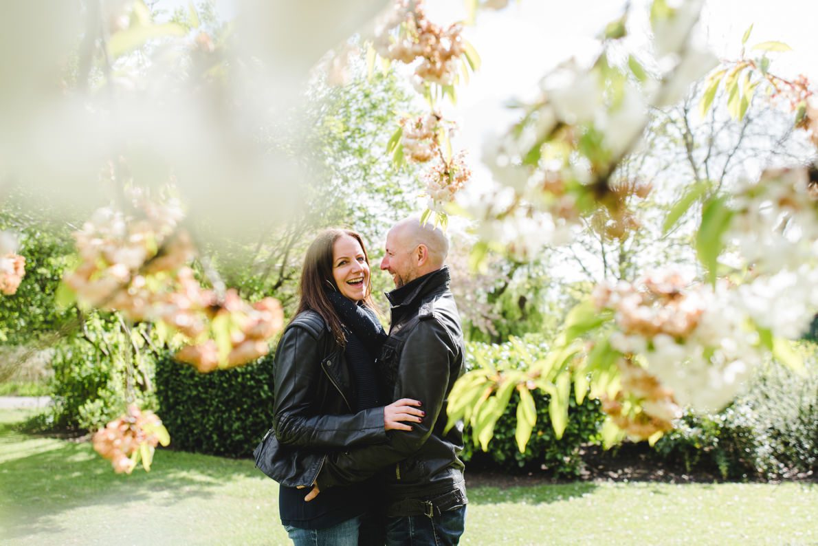 An engaged couple in front of blossom