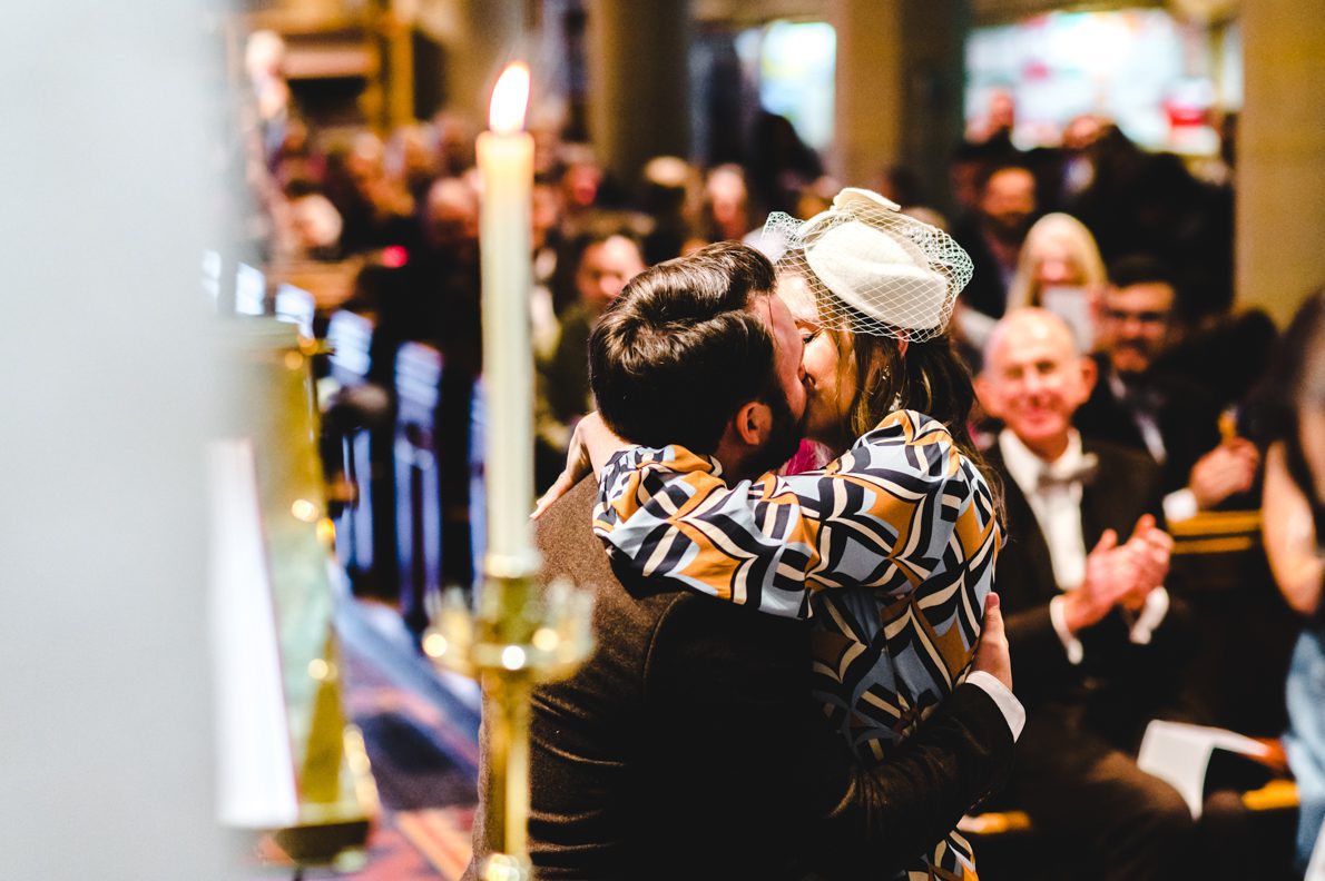 a first kiss in church at a wedding