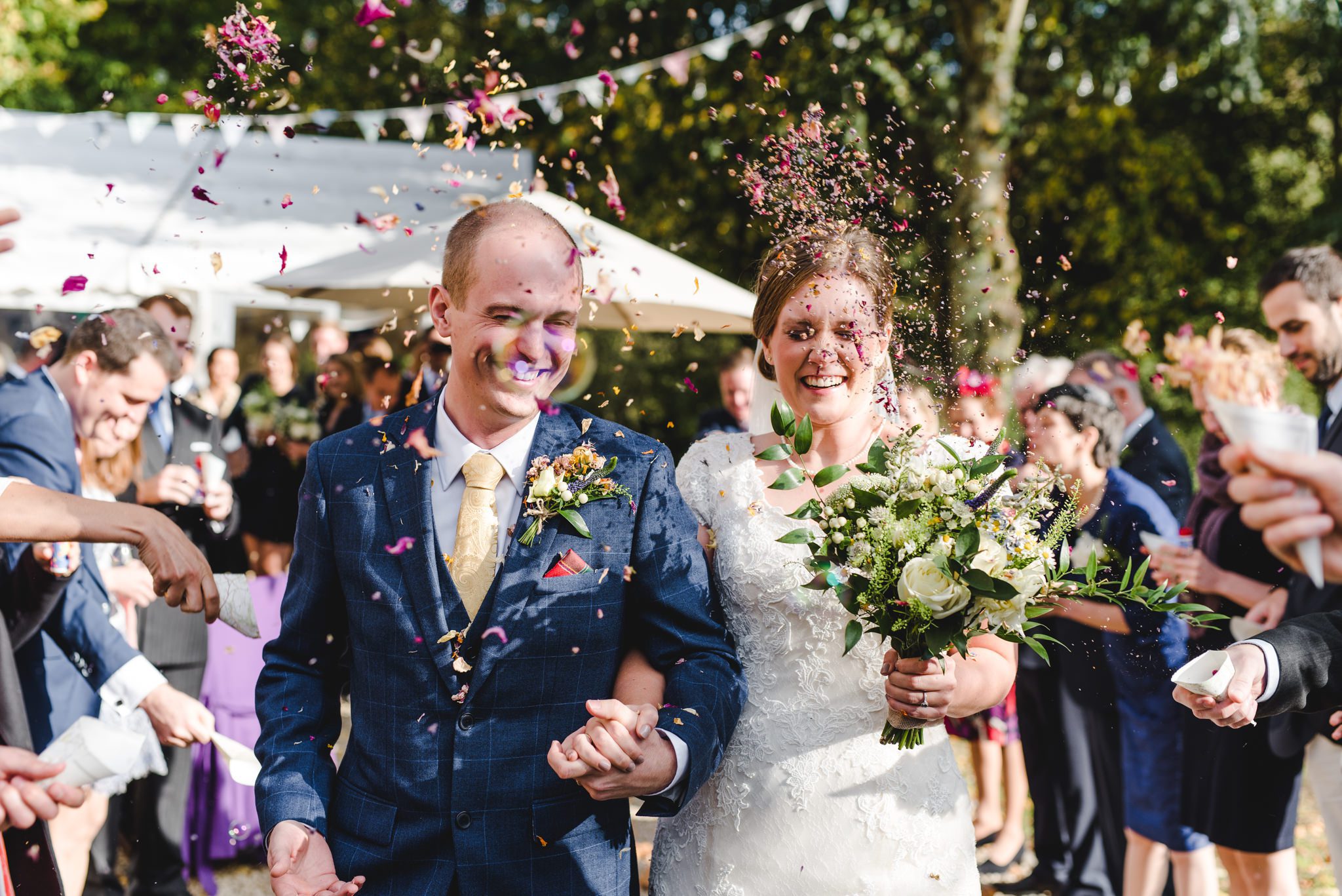 A couple covered in confetti at their Owlpen Manor Wedding