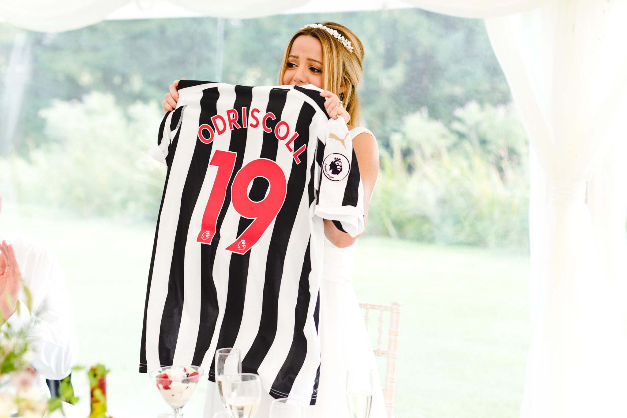 A bride holding up a Newcastle shirt