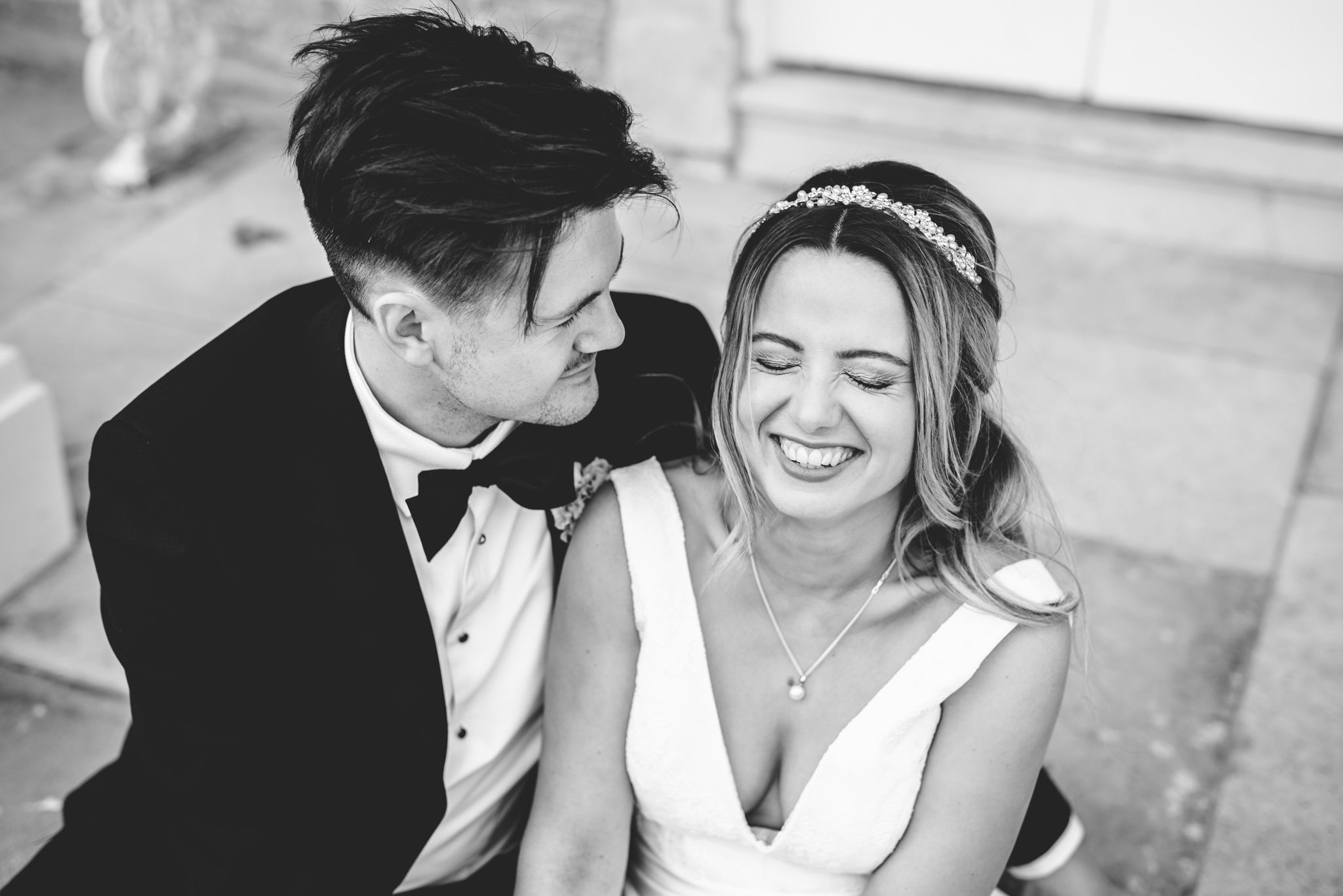 A bride and groom laughing at their wedding day